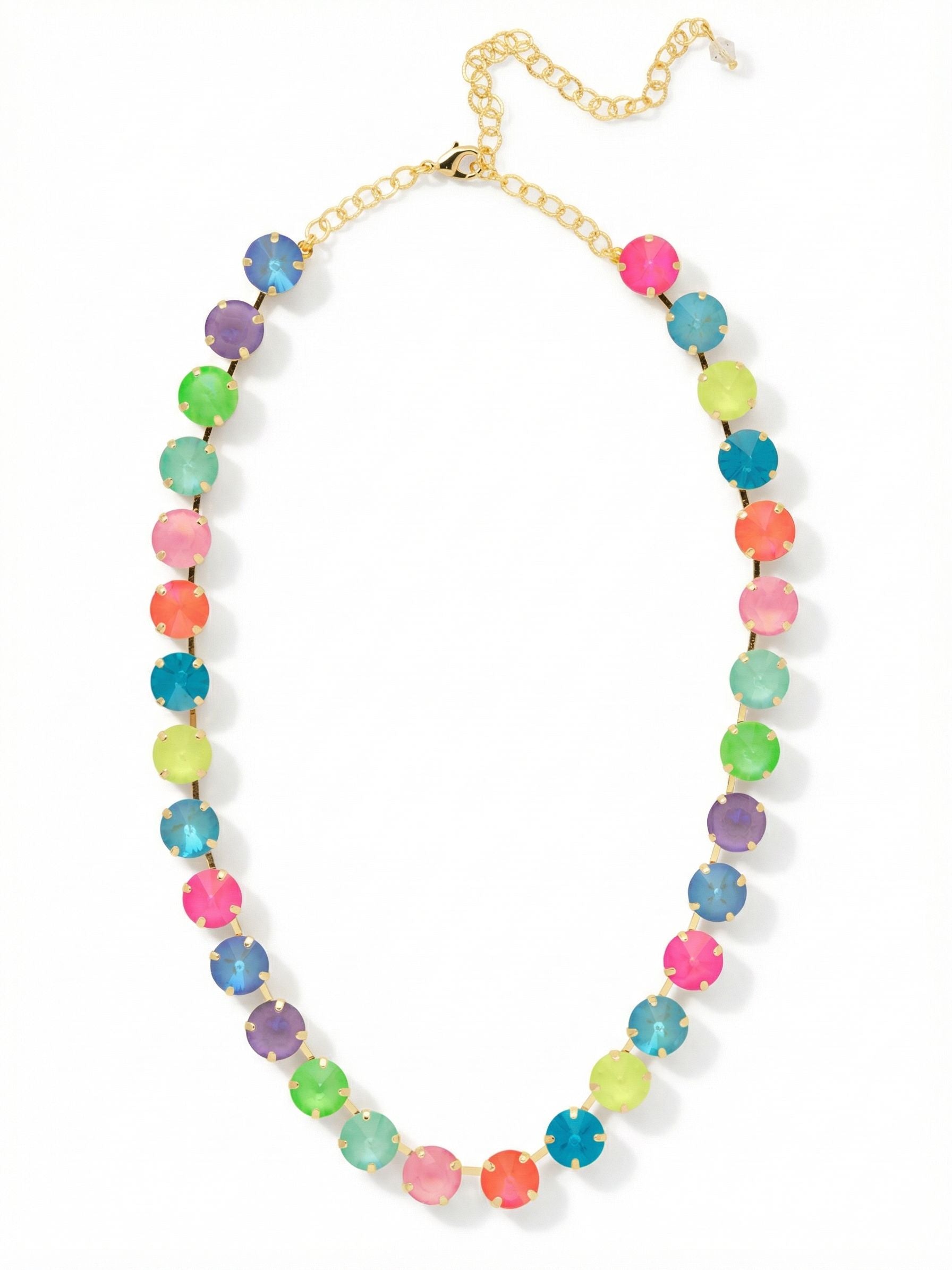 Mara Tennis Necklace - NFD75BGCCA - <p>Thirty large crystals form a bold circle of vibrant color around the neck. The fluid chain construction gives this piece a satisfying weight, allowing the stones to settle naturally along the collarbone without flipping as you move. Bright flashes of opal, electric pink, and saturated blue catch the light across a rhythmic mix of faceted cuts. An included four-inch extension chain lets you tailor the drape, so you can wear it high as a close collar or drop it lower to frame an open neckline.</p><ul>
<li>Ten distinct crystal colors arranged in a bold repeating spectrum</li>
<li>Fluid chain construction prevents the large stones from flipping</li>
<li>Lobster claw clasp</li>
<li>Protective e-coat finish for lasting wear</li>
<li>Includes signature organza pouch for gifting and travel</li>
</ul>