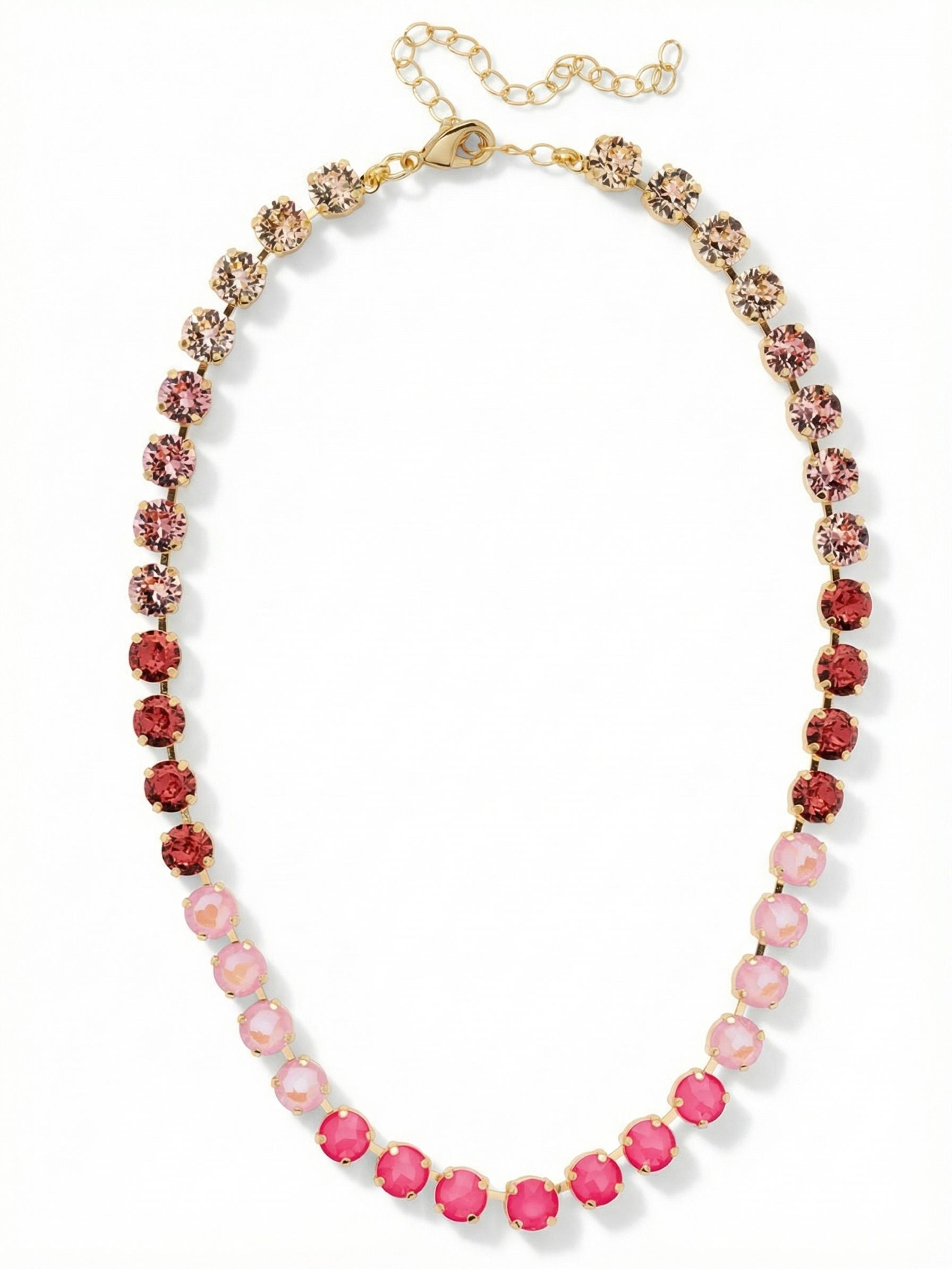 Matilda Tennis Necklace - NFJ4BGBFL - <p>A continuous line of round-cut crystals shifts through a deliberate gradient of warm pinks and soft neutrals. The kette chain construction allows each stone to articulate cleanly, following the natural curve of your collarbone without flipping or twisting. Vibrant electric pinks anchor the center of the drape, gradually softening to pale rose and warm silk toward the nape of the neck. The bright gold-tone setting frames this color transition, creating an unbroken collar of light. An extension chain lets you adjust the drop precisely to your neckline.</p><ul>
<li>Gradient color progression from electric pink to soft neutral silk</li>
<li>Fluid kette chain allows stones to articulate cleanly on the collarbone</li>
<li>Lobster claw clasp</li>
<li>4-inch adjustable extension chain</li>
<li>Protective e-coat finish for lasting wear</li>
<li>Includes signature organza pouch for gifting and travel</li>
</ul>