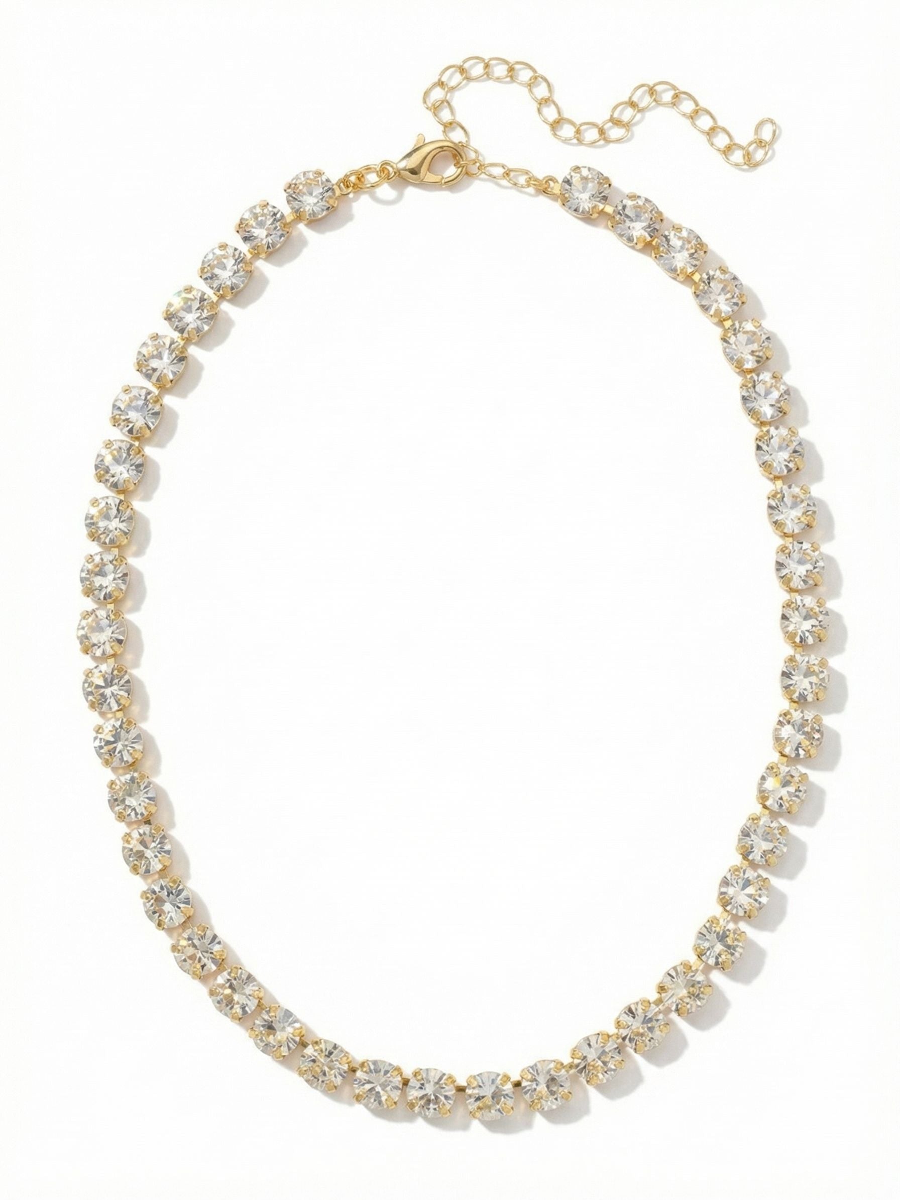 Matilda Tennis Necklace - NFJ4BGCRY - <p>The Matilda Tennis Necklace offers an unbroken line of light at the collarbone. Round-cut clear crystals are set close together in a fluid kette chain, creating a continuous band of brightness that moves with you. The gold-tone setting adds warmth, contrasting beautifully with the clarity of the stones. This piece has enough weight to drape naturally and stay in place, making it an easy foundation for layering or a singular focal point against bare skin. An adjustable extension chain allows you to tailor the drop exactly to your neckline.</p><ul>
<li>Unbroken line of closely set round-cut crystals</li>
<li>Fluid kette chain construction for a natural collarbone drape</li>
<li>Lobster claw clasp</li>
<li>4-inch adjustable extension chain</li>
<li>Protective e-coat finish for lasting wear</li>
<li>Includes signature organza pouch for gifting and travel</li>
</ul>
