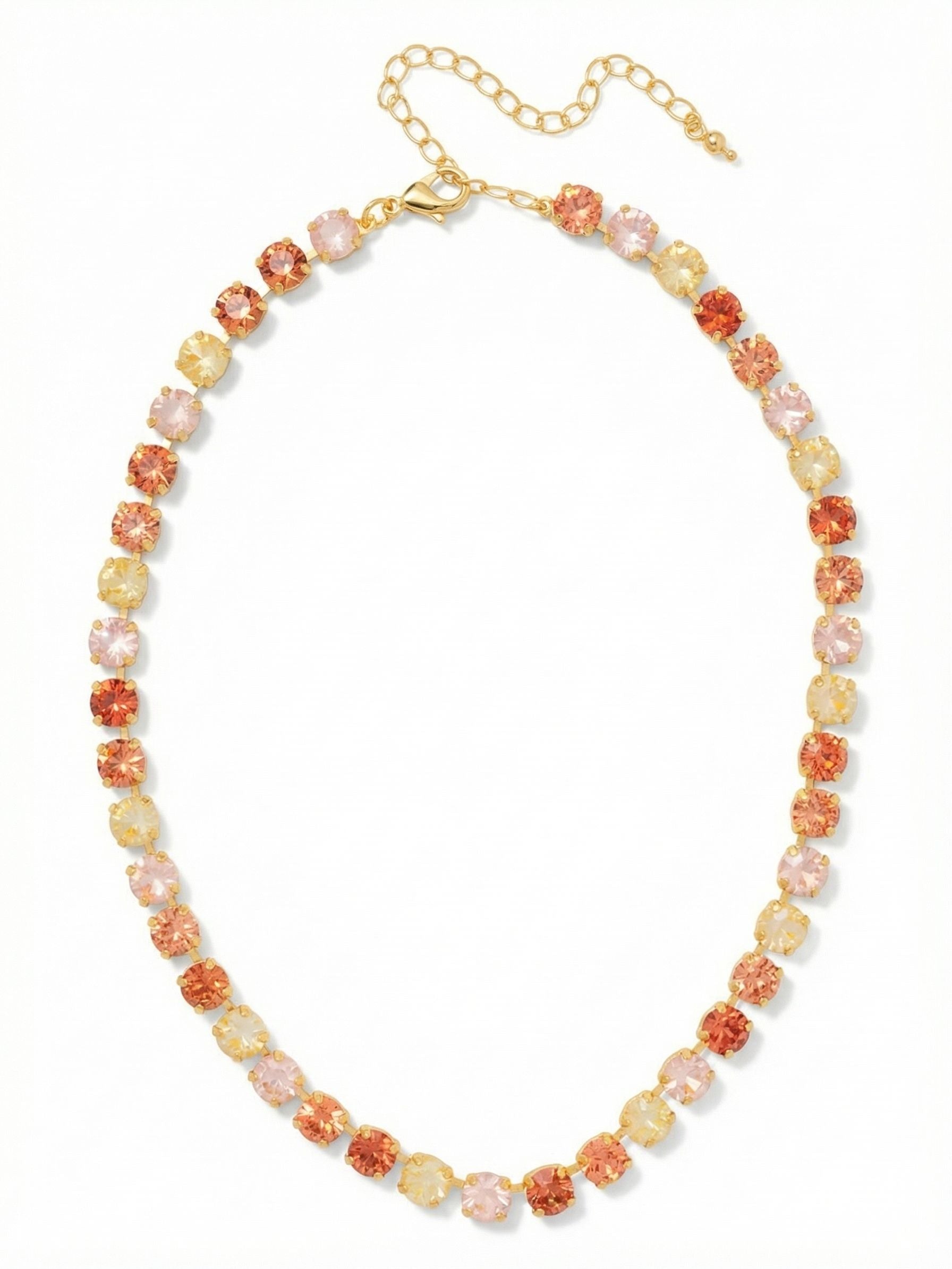 Matilda Tennis Necklace - NFJ4BGMOR - <p>A continuous line of warm sunset hues brings a distinct energy to the collarbone. Vibrant orange pinks and soft golden yellow crystals repeat in a rhythmic pattern of bright light. The flexible channel chain construction allows every round cut stone to articulate cleanly as you move. The necklace drapes securely around the base of the neck and includes an extension chain to control the exact drop. It is a substantial layer that easily holds its own while also anchoring a broader stack.</p><ul>
<li>Fluid kette chain construction allows the settings to flex and drape naturally</li>
<li>Alternating warm-toned round crystals create a vibrant rhythm of light</li>
<li>Lobster claw clasp</li>
<li>4-inch adjustable extension chain</li>
<li>Protective e-coat finish for lasting wear</li>
<li>Includes signature organza pouch for gifting and travel</li>
</ul>