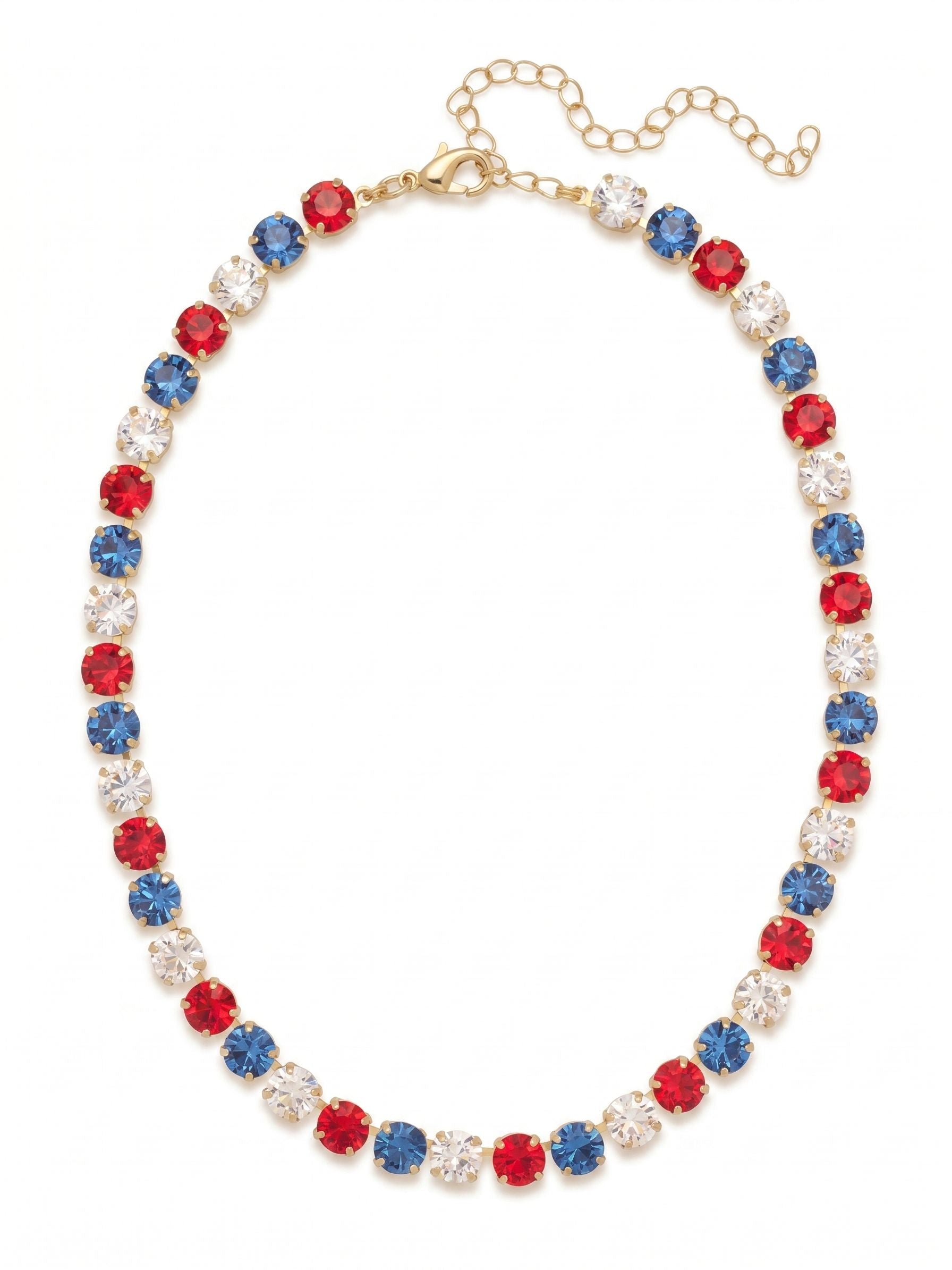 Matilda Tennis Necklace - NFJ4BGUSA - <p>A classic silhouette built for genuine impact. The Matilda wraps the neckline in a steady rhythm of large, round-cut crystals. Vibrant red, deep blue, and pure clear stones alternate along a flexible chain that conforms naturally to the collarbone. The substantial weight of the crystals grounds the piece with a quiet, confident presence, and the bright gold-tone setting warms up the crisp palette. Thanks to the extension chain, it transitions easily from a close collar profile to a more relaxed drape to suit your daily rotation.</p><ul>
<li>Alternating sequence of large round-cut crystals in a vivid tri-color palette</li>
<li>Fluid chain construction that drapes naturally across the collarbone</li>
<li>Lobster claw clasp</li>
<li>4-inch adjustable extension chain</li>
<li>Protective e-coat finish for lasting wear</li>
<li>Includes organza pouch for gifting and travel</li>
</ul>