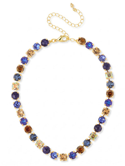 Matilda Choker Necklace - NFJ80BGDNM - <p>A classic tennis silhouette gains unexpected depth through varied textures. The Matilda Choker alternates faceted crystals in rich blues and warm ambers with smooth, opaque sodalite stones. Set in a flexible channel chain, the piece drapes comfortably at the base of the neck, catching the light differently across its mixed surfaces. The interplay of translucent sparkle and solid stone gives it a grounded presence suitable for daily wear. An included extension chain lets you adjust the fit precisely to your collarbone, making it an easy companion for open necklines.</p><ul>
<li>Alternating rhythm of faceted crystals and smooth opaque stones</li>
<li>Flexible crystal-set channel chain designed to drape naturally</li>
<li>Lobster claw clasp</li>
<li>4-inch adjustable extension chain</li>
<li>Protective e-coat finish for lasting wear</li>
<li>Includes signature organza pouch for gifting and travel</li>
</ul>