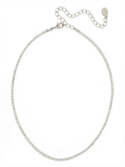 Mini Marnie Choker Tennis Necklace - NFL22PDCRY - <p>A single, unbroken thread of crystal designed to rest just above the collarbone. The delicate scale of this choker offers a quiet alternative to heavier tennis necklaces, catching the light with a continuous glimmer. Built on a flexible rhinestone chain, it contours naturally to the neckline without feeling rigid. It includes a four-inch extension chain, allowing you to fine-tune the drape whether worn alone or as the foundation of a layered look.</p><ul>
<li>Ultra-fine continuous rhinestone chain</li>
<li>Delicate profile designed to rest high on the neckline</li>
<li>Lobster claw clasp</li>
<li>4-inch adjustable extension chain</li>
<li>Protective e-coat finish for lasting wear</li>
<li>Includes signature organza pouch for gifting and travel</li>
</ul>