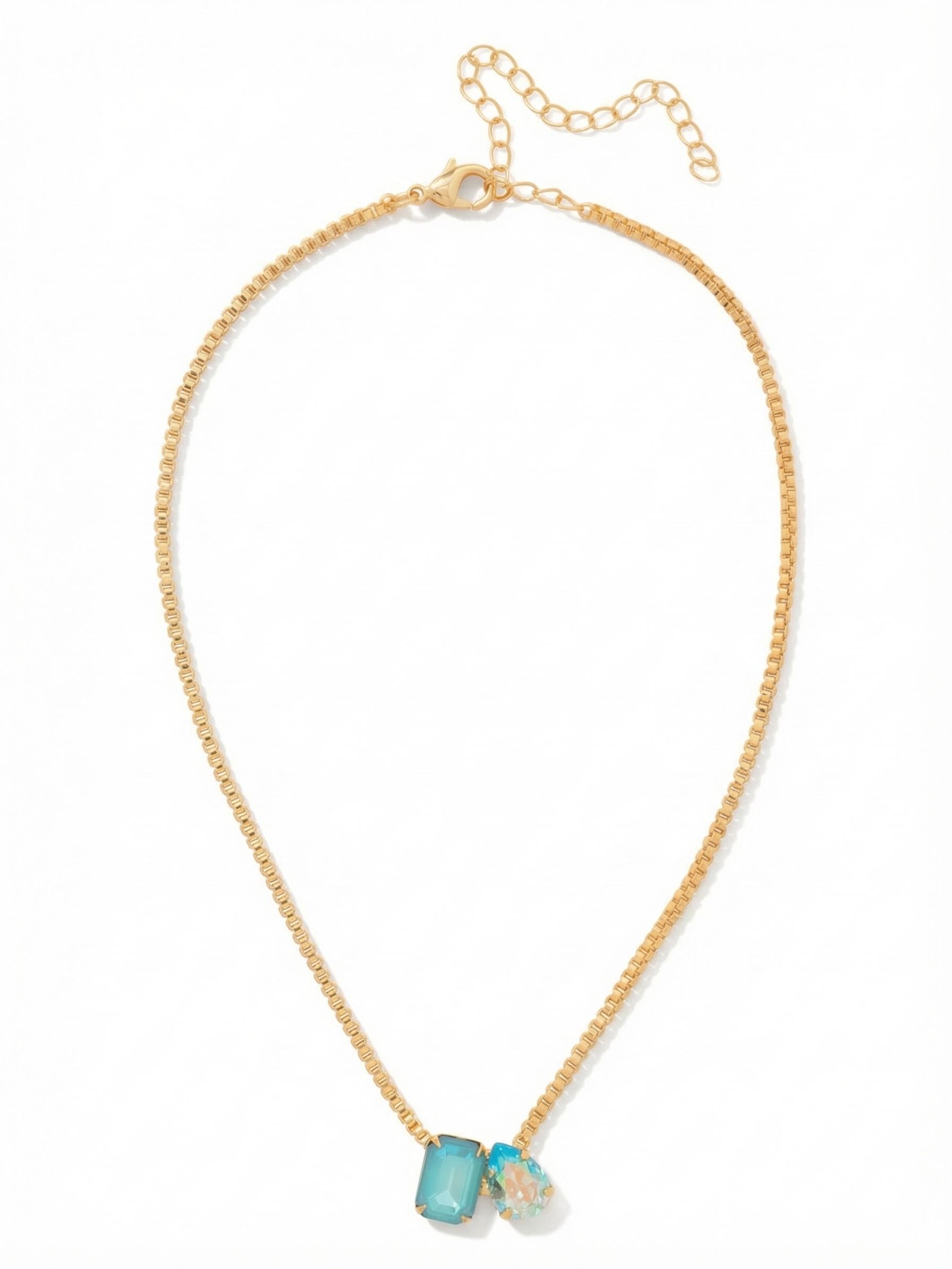 Emerald Pear Pendant Necklace - NFN3BGCSD - <p>Two distinct crystals meet slightly off-center on a fluid box chain. The architectural lines of an emerald-cut milky blue stone contrast organically with the faceted curves of an iridescent aquamarine drop. This asymmetric grouping anchors the piece with quiet intention at the collarbone. The flexible chain glides naturally against the skin and includes an adjustable extension, allowing you to tailor the drop to your exact neckline or layer it easily with longer vintage pieces.</p><ul>
<li>Asymmetrical cluster pairing a structured emerald cut with a fluid pear shape</li>
<li>Flexible box chain construction that drapes smoothly along the natural neckline</li>
<li>Lobster claw clasp</li>
<li>4-inch adjustable extension chain</li>
<li>Protective e-coat finish for lasting wear</li>
<li>Includes signature organza pouch for gifting and travel</li>
</ul>