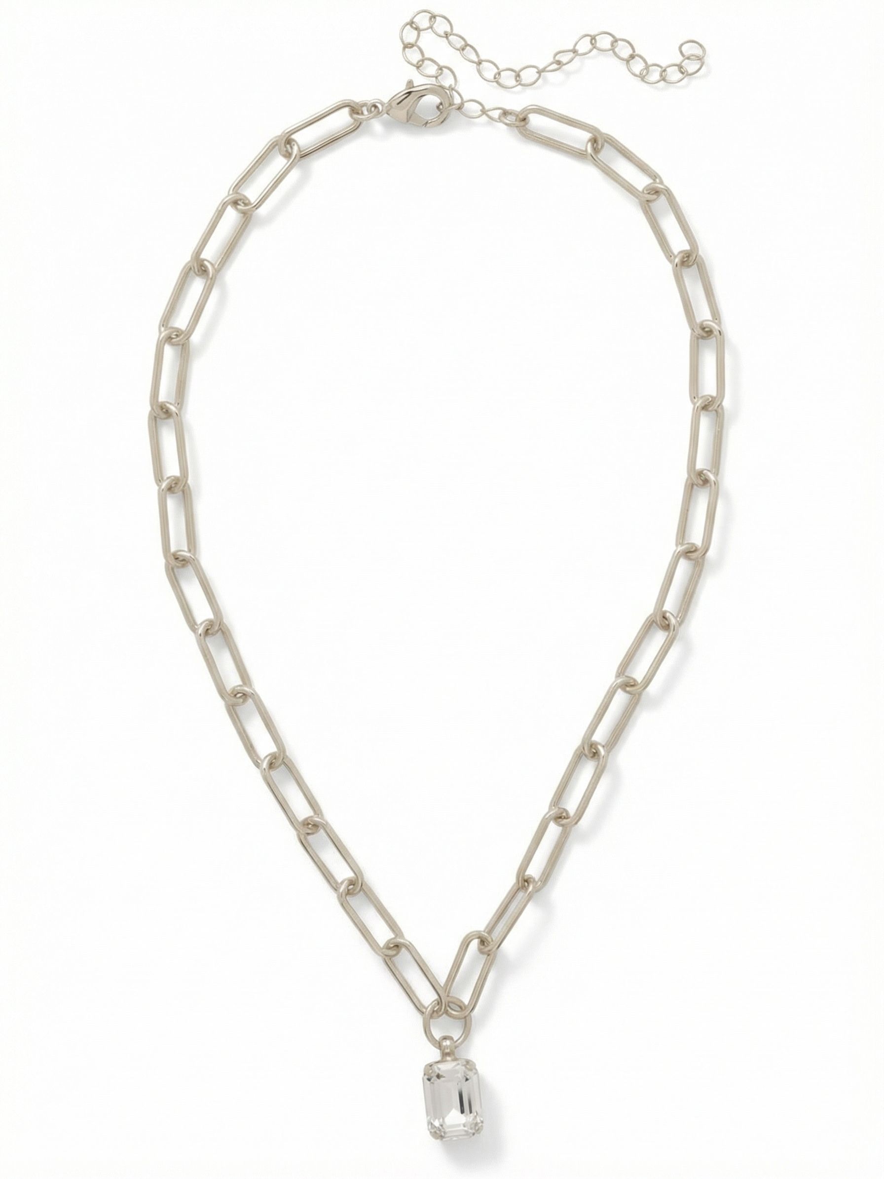 Nia Pendant Necklace - NFS7PDCRY - <p>A single emerald-cut crystal anchors this modern everyday piece, catching the light with clean, geometric precision. The pendant drops from an elongated paperclip chain, giving the necklace an airy, unstructured feel that moves fluidly as you go about your day. Designed to layer easily or hold its own, the built-in extension chain allows you to adjust the length to sit perfectly against any neckline. It brings a quiet, architectural polish to a simple tee or an open collar.</p><ul>
<li>Single emerald-cut clear crystal suspended from a circular ring</li>
<li>Elongated paperclip chain creates a modern open silhouette</li>
<li>Lobster claw clasp</li>
<li>4-inch adjustable extension chain</li>
<li>Protective e-coat finish for lasting wear</li>
<li>Includes signature organza pouch for gifting and travel</li>
</ul>