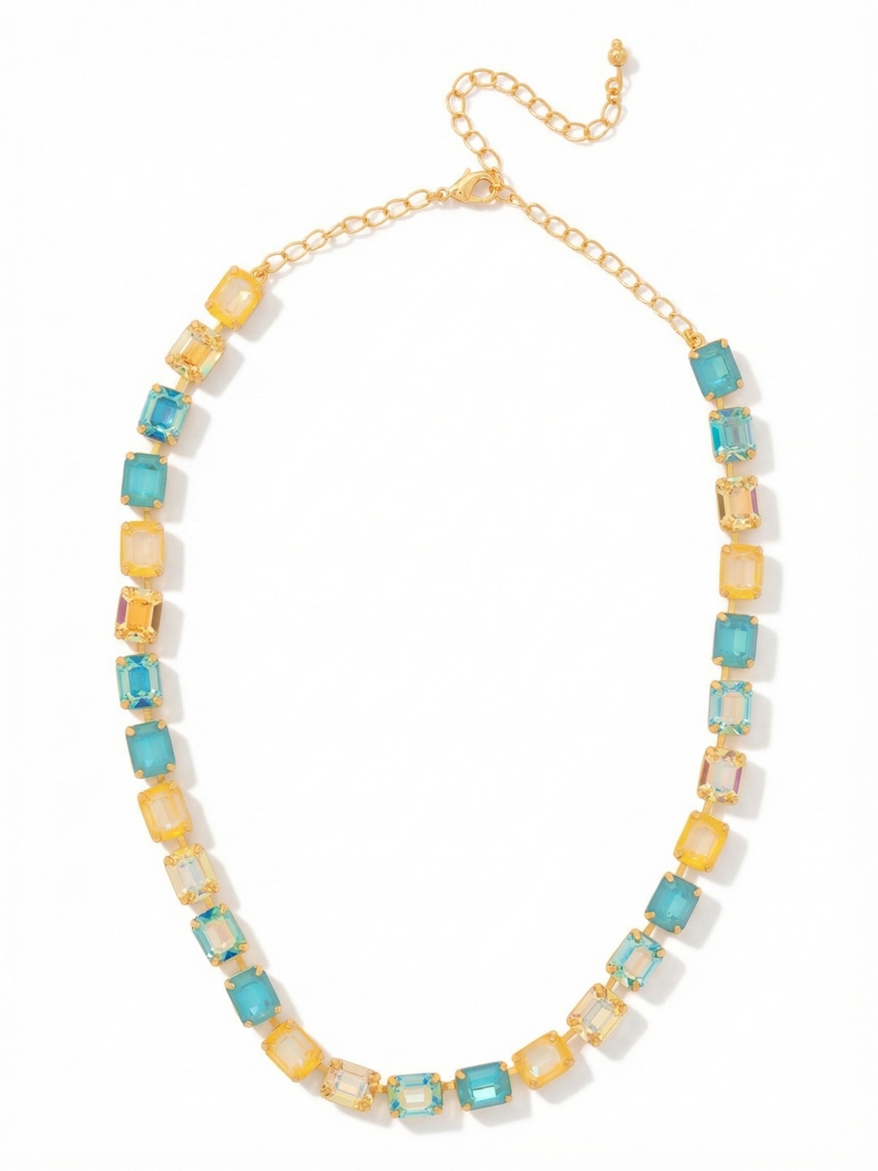 Octavia Repeating Tennis Necklace - NFY7BGCSD - <p>An unbroken line of saturated color frames the collarbone in this substantial tennis necklace. Alternating pairs of emerald-cut crystals shift smoothly from warm topaz to cool aquamarine, creating a steady geometric rhythm. The stones are closely set within a flexible channel chain that articulates with your natural movement, allowing the broad step cuts to continuously catch the light. At nearly half an inch wide, the necklace carries a comfortable, grounding weight. An extension chain ensures a precise drop to suit whatever neckline you choose.</p><ul>
<li>Alternating color pairs create a distinct rhythmic pattern along the collarbone</li>
<li>Broad step cuts catch the light in an unbroken geometric sequence</li>
<li>Lobster claw clasp</li>
<li>4-inch adjustable extension chain</li>
<li>Protective e-coat finish for lasting wear</li>
<li>Includes signature organza pouch for gifting and travel</li>
</ul>