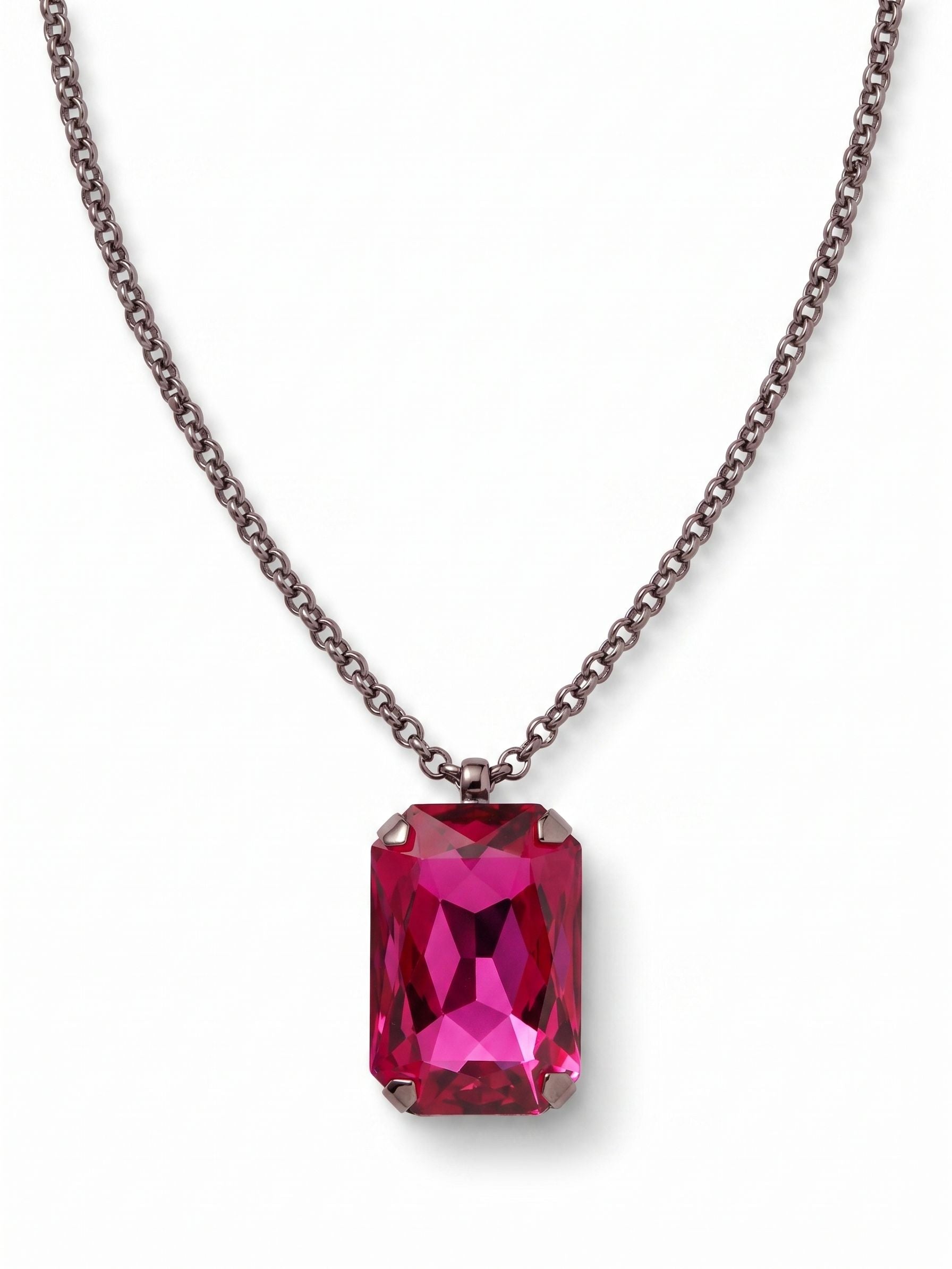 Viretta Pendant Necklace - NFZ16GMFU - <p>A singular, substantial emerald-cut crystal anchors this necklace, dropping cleanly from a fine rolo chain. The dark metal finish provides a quiet contrast to the vivid fuchsia stone, drawing the eye directly to its deep facets and architectural lines. The pendant carries a satisfying physical weight that grounds the delicate chain right at the collarbone. It stands as a confident focal point with enough presence to wear entirely on its own, while the extension chain lets you dial in the exact drop.</p><ul>
<li>Fine rolo chain contrasts with the heavy weight of the central focal stone</li>
<li>Prominent prong setting emphasizes the clean geometric lines of the emerald cut</li>
<li>Lobster claw clasp</li>
<li>4-inch adjustable extension chain</li>
<li>Includes signature organza pouch for gifting and travel</li>
</ul>