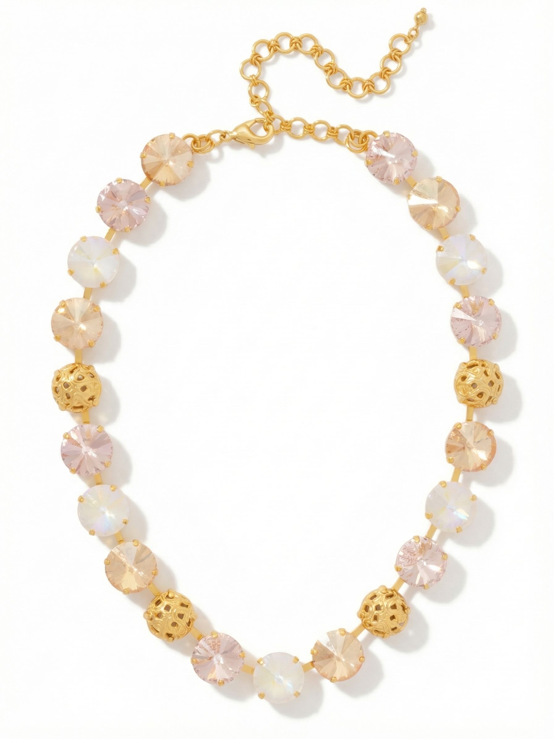 Clementine Tennis Necklace - NFZ18BGGGO - <p>The Clementine Tennis Necklace wraps the collarbone in a warm, rhythmic progression of light. Large round crystals in soft blush, golden shadow, and iridescent white alternate with intricately textured golden spheres, creating an unbroken line that moves seamlessly with you. The articulated chain ensures the piece drapes comfortably, while the extension allows you to adjust the drop precisely to your neckline. It brings a soft radiance to a simple silk blouse or an open collar, catching the light with a quiet, continuous glow.</p><ul>
<li>Alternates large round pastel crystals with finely textured openwork metallic spheres</li>
<li>Articulated channel chain maintains fluid movement along the collarbone</li>
<li>Lobster claw clasp</li>
<li>4-inch adjustable extension chain</li>
<li>Protective e-coat finish for lasting wear</li>
<li>Includes signature organza pouch for gifting and travel</li>
</ul>