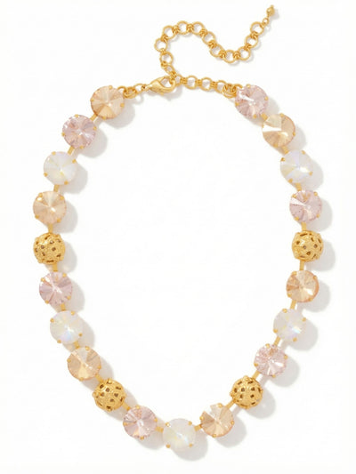 Clementine Tennis Necklace - NFZ18BGGGO - <p>The Clementine Tennis Necklace wraps the collarbone in a warm, rhythmic progression of light. Large round crystals in soft blush, golden shadow, and iridescent white alternate with intricately textured golden spheres, creating an unbroken line that moves seamlessly with you. The articulated chain ensures the piece drapes comfortably, while the extension allows you to adjust the drop precisely to your neckline. It brings a soft radiance to a simple silk blouse or an open collar, catching the light with a quiet, continuous glow.</p><ul>
<li>Alternates large round pastel crystals with finely textured openwork metallic spheres</li>
<li>Articulated channel chain maintains fluid movement along the collarbone</li>
<li>Lobster claw clasp</li>
<li>4-inch adjustable extension chain</li>
<li>Protective e-coat finish for lasting wear</li>
<li>Includes signature organza pouch for gifting and travel</li>
</ul>
