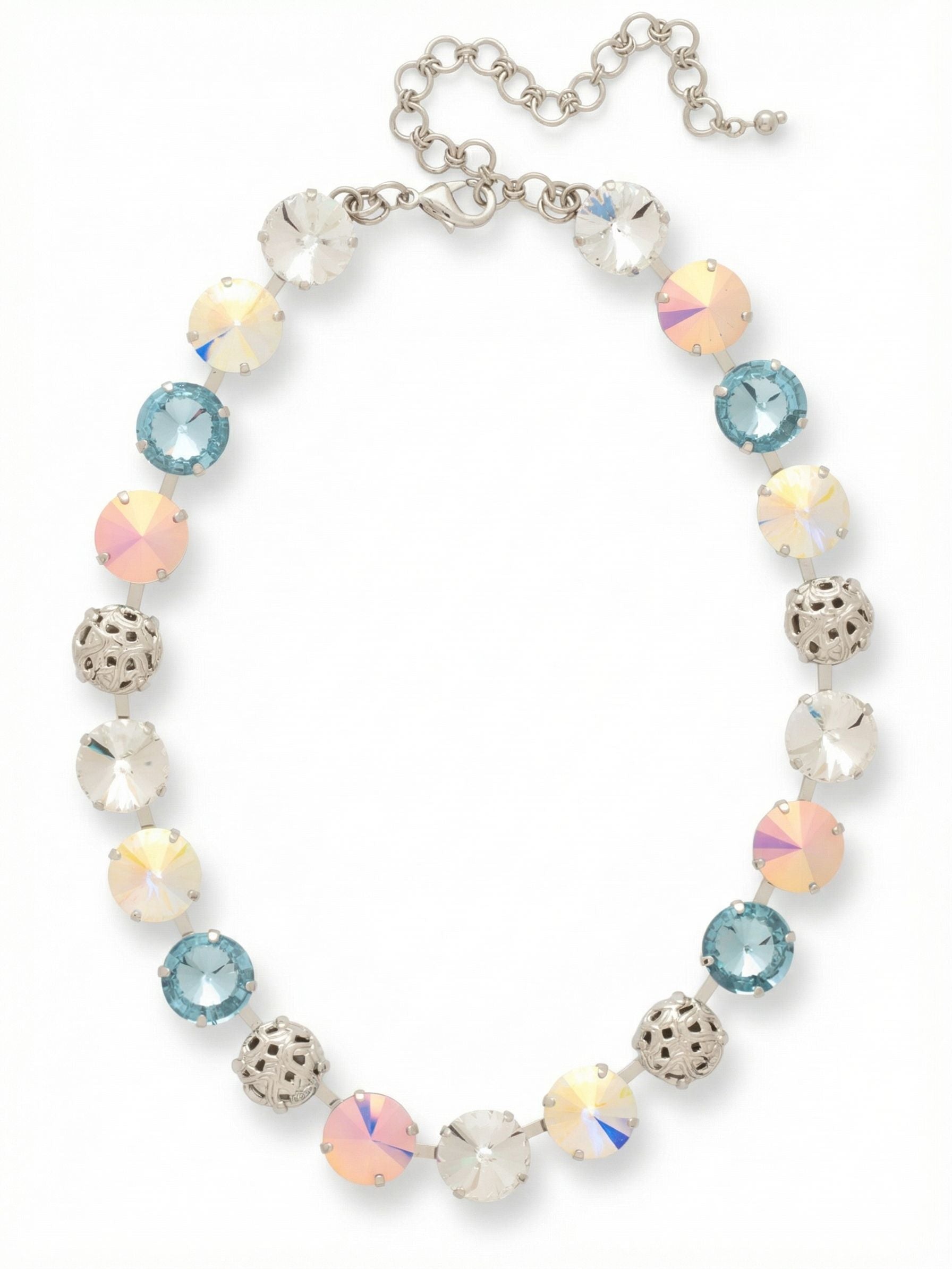 Clementine Tennis Necklace - NFZ18PDRQ - <p>This tennis necklace anchors your neckline with a continuous rhythm of light and texture. Large round and faceted-cut crystals alternate with intricate filigree spheres, creating a balanced weight that drapes evenly across the collarbone. The pastel palette catches ambient light, shifting between pale blue, clear, and iridescent tones as you move. Built on a flexible crystal-set channel chain, the piece curves cleanly to the shape of your neck without twisting. An included extension chain allows you to adjust the drop to suit different necklines.</p><ul>
<li>Alternating sequence of round crystals and metal filigree spheres</li>
<li>Flexible channel chain construction follows the collarbone without twisting</li>
<li>Lobster claw clasp</li>
<li>4-inch adjustable extension chain</li>
<li>Protective e-coat finish for lasting wear</li>
<li>Includes signature organza pouch for gifting and travel</li>
</ul>