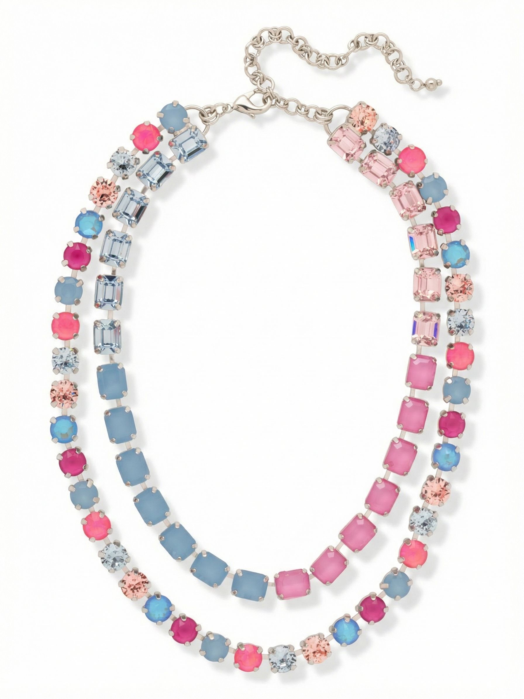 Marci Tennis Necklace - NFZ2PDPBZ - <p>The Marci Tennis Necklace delivers perfectly spaced layering in a single piece. An inner row of structured emerald-cut crystals rests near the collarbone, framed by an outer sweep of round-cut stones. The setting connects a vivid gradient of pink and blue tones, creating a deliberate color shift that catches light. Built on a flexible crystal-set chain, the design drapes comfortably without twisting. An integrated extension chain lets you precisely adjust the drop, bringing substantial weight and architectural symmetry to an open neckline.</p><ul>
<li>Double-row silhouette combining emerald cuts and round stones</li>
<li>Fluid color progression from vibrant pinks to muted blue opals</li>
<li>Lobster claw clasp</li>
<li>4-inch adjustable extension chain</li>
<li>Protective e-coat finish for lasting wear</li>
<li>Includes signature organza pouch for gifting and travel</li>
</ul>