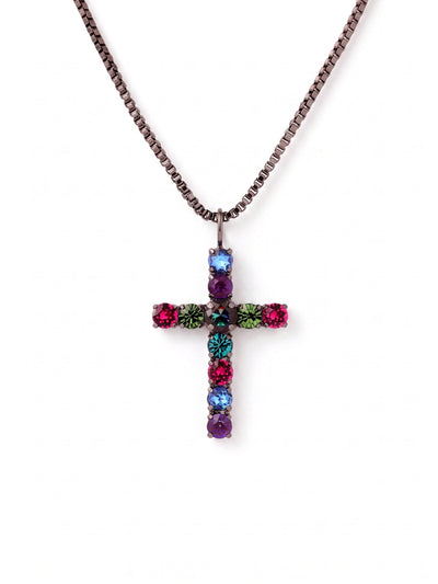 Crystal Cross Pendant Necklace - NFZ90GMNNI - <p>This cross pendant anchors a vibrant spectrum of jewel-toned crystals against a dark, structured box chain. The larger central stone catches the light with a moody depth, surrounded by precise arrangements of fuchsia, emerald, and blue zircon. A gunmetal setting creates a sharp, modern contrast that keeps the bright stones grounded. Suspended on a fluid chain with an adjustable extension, the pendant finds its natural place resting just below the collarbone. It brings an assertive, colorful presence to a simple silk blouse or a dark knit.</p><ul>
<li>Symmetrical spectrum of vibrant crystals anchored by a larger central stone</li>
<li>Fluid box chain provides a sleek and structured drape</li>
<li>Lobster claw clasp</li>
<li>4-inch adjustable extension chain</li>
<li>Includes organza pouch for gifting and travel</li>
</ul>