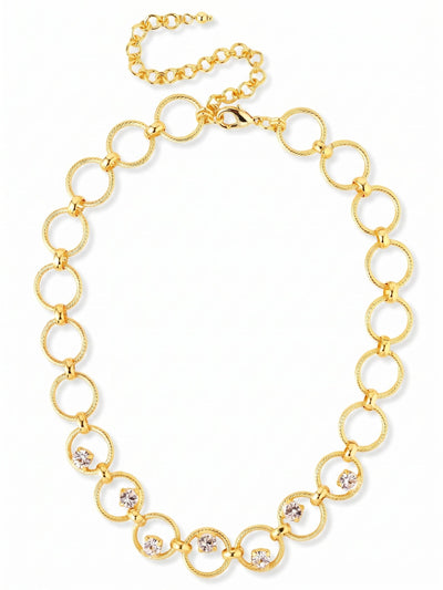 Odessa Tennis Necklace - NGI1BGCRY - <p>Large textured rings form a bold, substantial collar that frames the face with warmth. Along the front curve, round clear crystals are anchored within the links, offering flashes of light as you move. The twisted metal catches shadows and highlights, giving the chain a tactile depth that feels grounded on the collarbone. With its built-in extension chain, you can easily adjust the drape to sit precisely above your chosen neckline.</p><ul>
<li>Textured interlocking rings create a bold open-link profile</li>
<li>Round crystals set inside the front links add unexpected dimension</li>
<li>Lobster claw clasp</li>
<li>4-inch adjustable extension chain</li>
<li>Protective e-coat finish for lasting wear</li>
<li>Includes organza pouch for gifting and travel</li>
</ul>