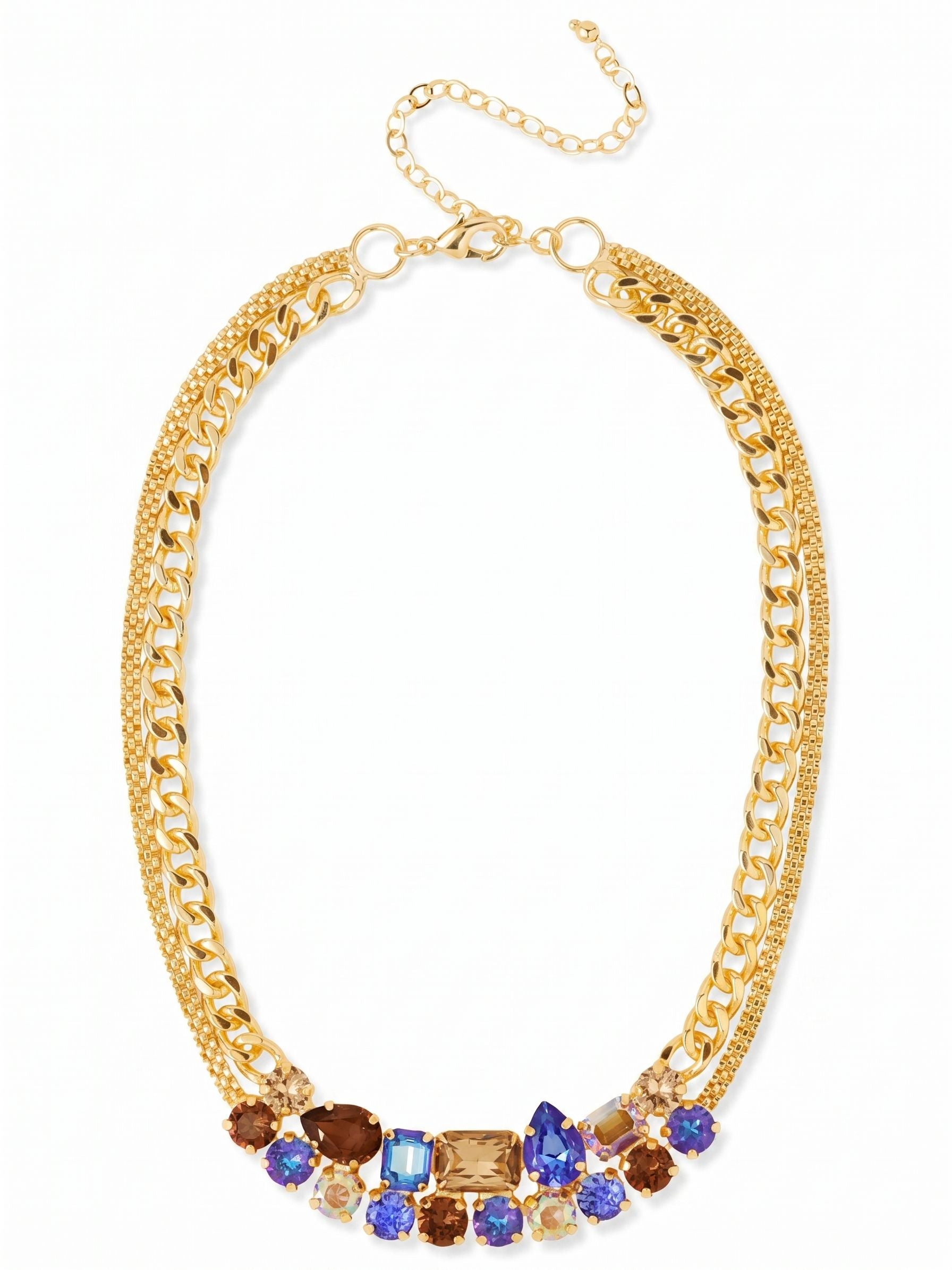 Moxie Tennis Necklace - NGI4BGDNM - <p>A heavy cluster of mixed-cut crystals anchors this necklace right at the collarbone. Emerald, pear, and round stones in deep sapphires and smoked topaz create a rich focal point that balances the bright gold-tone hardware. The crystal arrangement is flanked by contrasting textures, blending classic cable links with flexible mesh and kette chains. The weight of the center stones keeps the piece grounded as you move, while the four-inch extension chain lets you adjust the drape depending on your neckline.</p><ul>
<li>Dense focal cluster of pear, emerald, and round cut crystals</li>
<li>Textural mix of cable, mesh, and kette chains</li>
<li>Lobster claw clasp</li>
<li>Protective e-coat finish for lasting wear</li>
<li>Includes organza pouch for gifting and travel</li>
</ul>