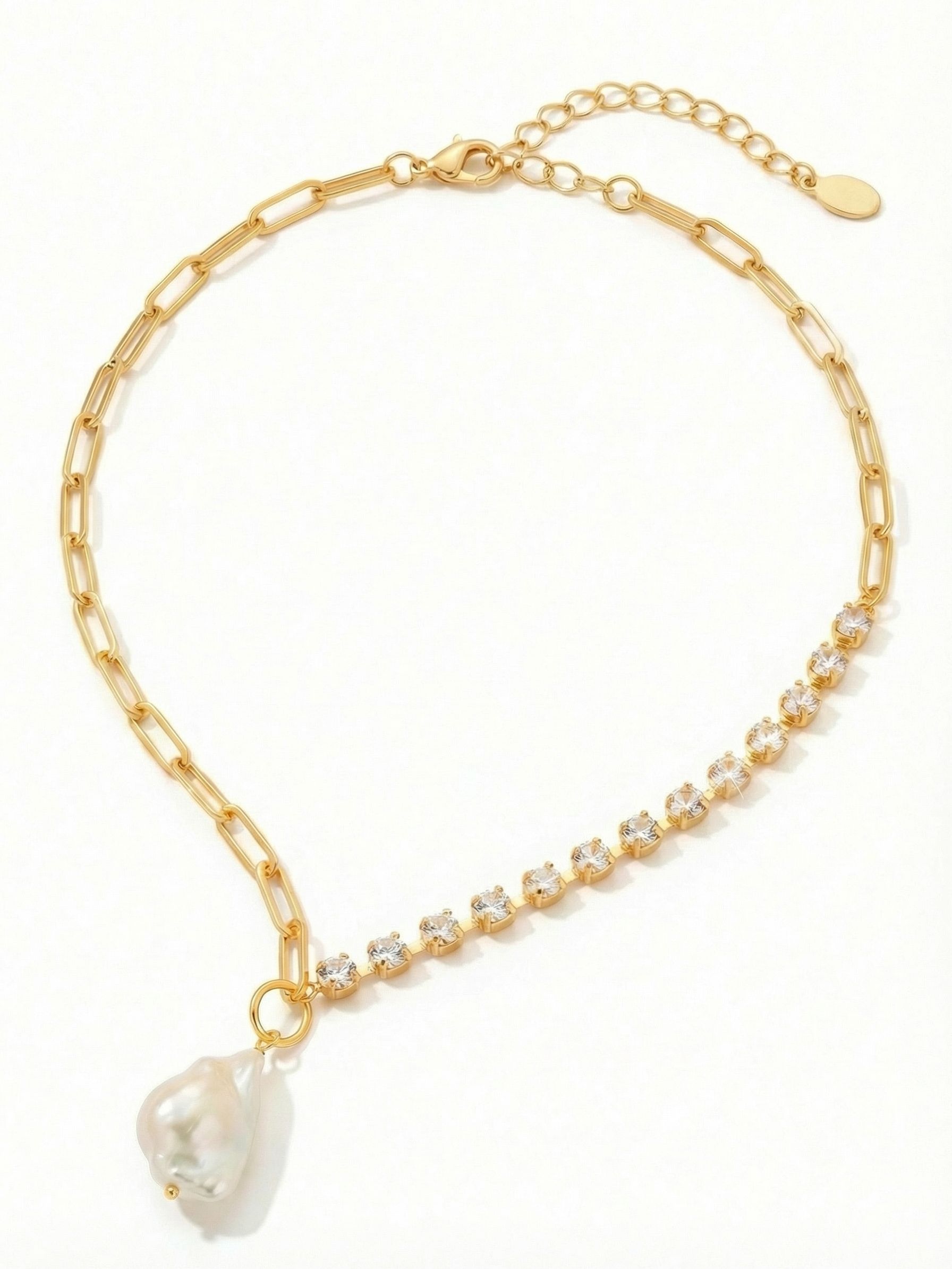 Iris Pendant Necklace - NGI5BGMDP - <p>The Iris pendant leans into deliberate asymmetry. One side drapes the collar in an airy paperclip chain, meeting a continuous line of clear crystals on the opposite side. Right at the junction, a single oversized baroque pearl drops to anchor the design. The pearl's organic, irregular shape offers a soft contrast to the structured metal and provides a satisfying weight that sways slightly as you move. An extension chain lets you position the drop exactly where it suits your neckline.</p><ul>
<li>Asymmetric half paperclip and half crystal-set chain design</li>
<li>Oversized organic baroque pearl pendant with natural variance</li>
<li>Lobster claw clasp</li>
<li>4-inch adjustable extension chain</li>
<li>Protective e-coat finish for lasting wear</li>
<li>Includes signature organza pouch for gifting and travel</li>
</ul>