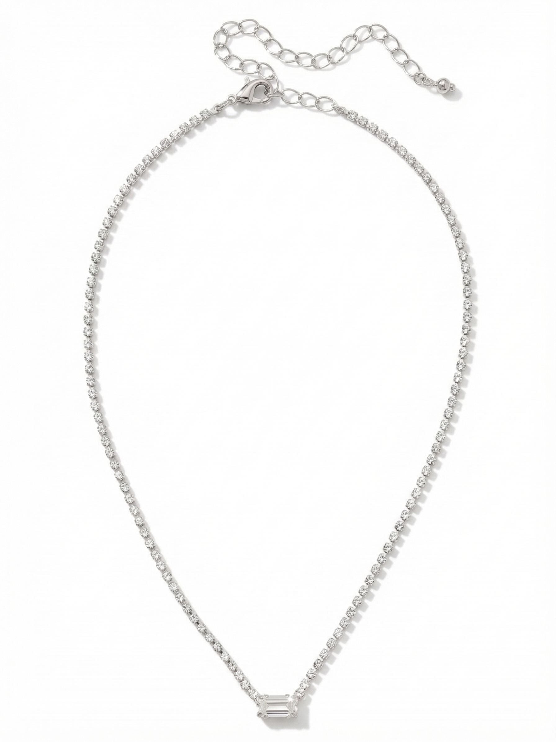 Mini Marnie Baguette Pendant Necklace - NGJ1PDCRY - <p>A fine thread of continuous light meets a structured geometric center. The Mini Marnie necklace anchors a delicate rhinestone chain with a single horizontal baguette crystal. This clean, linear focal point draws the eye while resting effortlessly near the collarbone. With the included extension chain, you can easily adjust the placement from a close fit to a slightly more relaxed drape. It brings a quiet, intentional presence to an open collar or a simple silk shirt.</p><ul>
<li>Single horizontally set baguette crystal creates a sharp geometric focal point</li>
<li>Continuous rhinestone base chain provides unbroken light around the neckline</li>
<li>Lobster claw clasp</li>
<li>4-inch adjustable extension chain</li>
<li>Protective e-coat finish for lasting wear</li>
<li>Includes signature organza pouch for gifting and travel</li>
</ul>