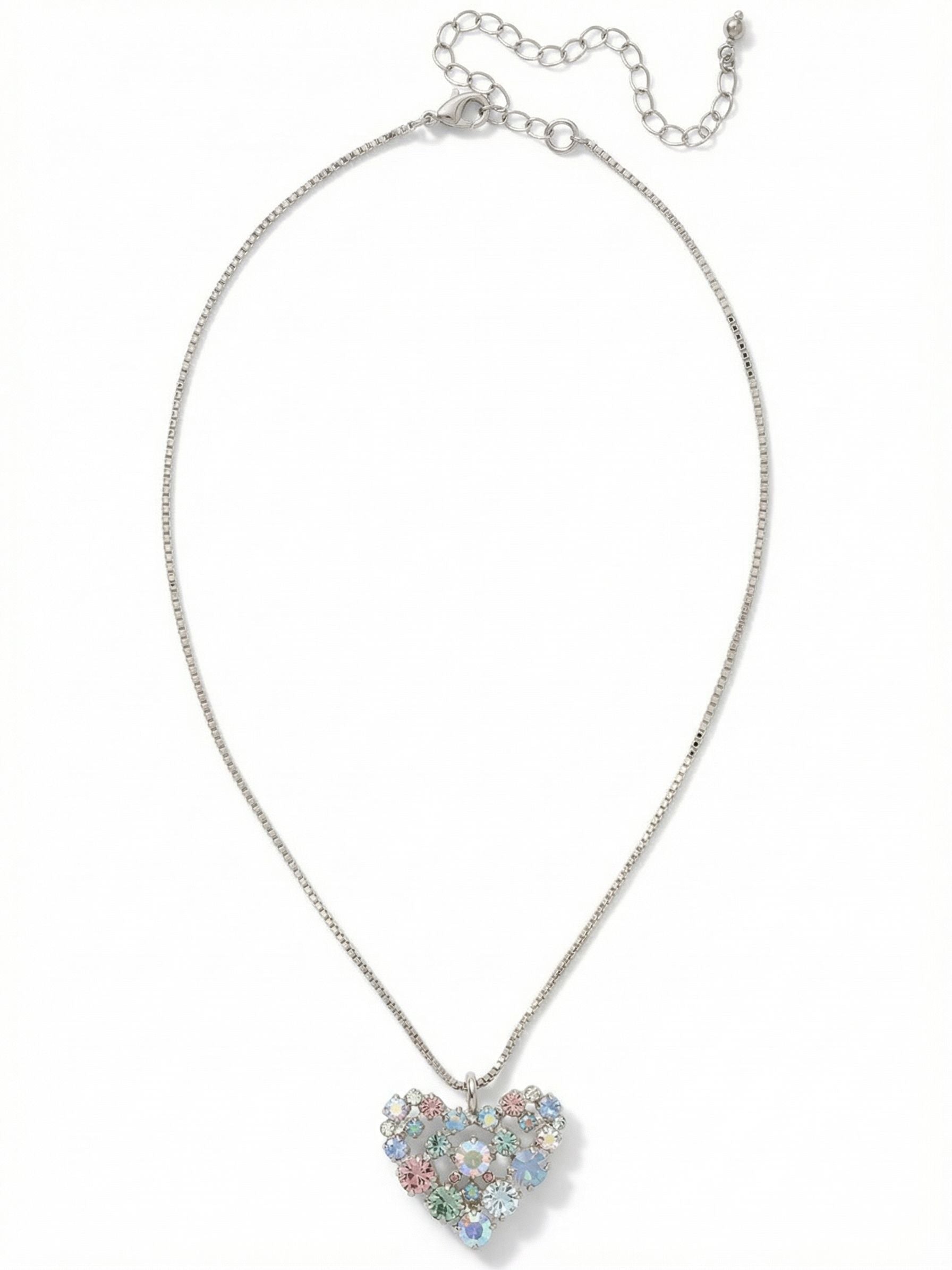 Crystal Heart Pendant Necklace - NGK2PDRQ - <p>Suspended from a fluid box chain, this open-work heart pendant balances precise geometry with a soft wash of color. The arrangement of pale blue, gentle rose, and iridescent crystals catches the light from multiple angles, shifting gently as you move through your day. The chain drapes smoothly across the collarbone, and the built-in extension allows you to adjust the drop. It brings a quiet, intentional presence to a simple silk blouse or a favorite knit sweater.</p><ul>
<li>Open-work heart silhouette formed by clustered mixed-scale crystals</li>
<li>Fluid box chain construction offers a smooth and continuous drape</li>
<li>Lobster claw clasp</li>
<li>4-inch adjustable extension chain</li>
<li>Protective e-coat finish for lasting wear</li>
<li>Includes signature organza pouch for gifting and travel</li>
</ul>