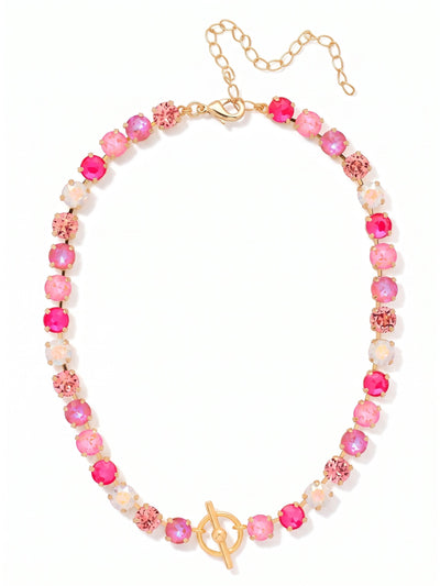 Matilda Toggle Tennis Necklace - NGM1BGPIN - <p>A line of light rose, electric pink, and iridescent round-cut crystals brings immediate warmth to the neckline. The classic tennis silhouette is anchored by a decorative gold-tone toggle that rests at the collarbone, creating a distinctive focal point. Built on a flexible kette chain, the piece drapes smoothly and moves comfortably as you wear it. Designed with an adjustable extension at the back, it layers easily over a silk top or sits neatly inside an open collar.</p><ul>
<li>Decorative front toggle creates a central focal point at the neckline</li>
<li>Vibrant mix of electric pink and iridescent aurora borealis crystals</li>
<li>Lobster claw clasp</li>
<li>4-inch adjustable extension chain</li>
<li>Protective e-coat finish for lasting wear</li>
<li>Includes organza pouch for gifting and travel</li>
</ul>