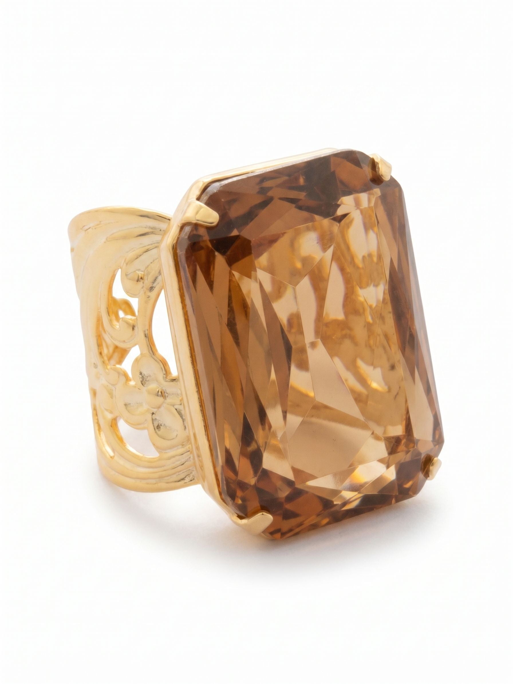 Viretta Adjustable Cocktail Ring - RBT67BGLC - <p>A single, substantial emerald-cut crystal anchors this cocktail ring, drawing light deep into its faceted surface. The warm, amber tone commands attention on the hand with quiet authority. We designed the wide, pierced metal band to provide comfortable structure, balancing the weight of the central stone. An open back allows for an adjustable fit, giving you the freedom to move the piece between fingers as the day requires.</p><ul>
<li>Oversized emerald-cut crystal draws light deep into its stepped facets</li>
<li>Wide pierced band balances the proportion of the central stone</li>
<li>Adjustable ring band</li>
<li>Protective e-coat finish for lasting wear</li>
<li>Includes signature organza pouch for gifting and travel</li>
</ul>