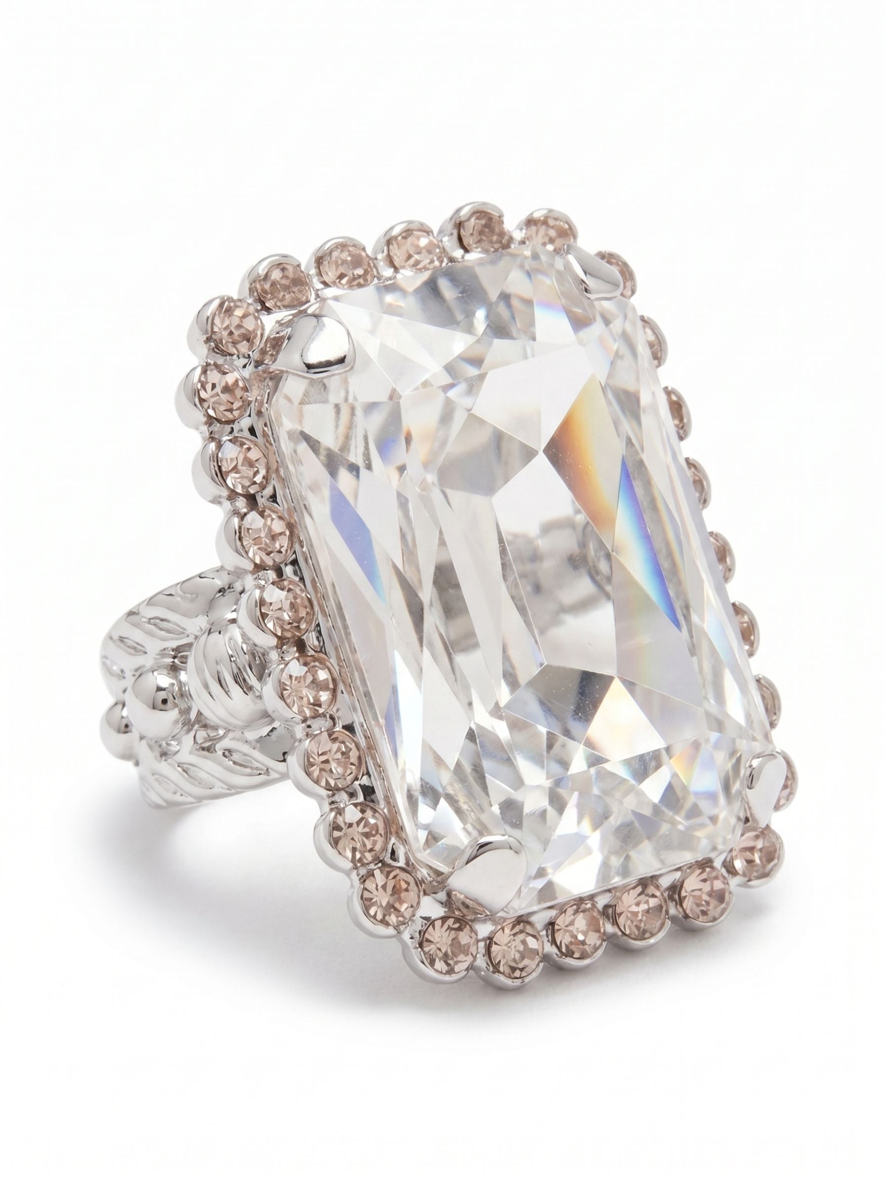 Luxurious Emerald-Cut Cocktail Ring - RBT69PDSNB - <p>A single oversized emerald-cut crystal gives this cocktail ring substantial presence on the hand. The clear stone catches light through broad geometric facets, framed by a delicate border of ball and rhinestone chains that adds quiet texture to the crisp profile. Designed with an open band, the fit easily adapts so you can move the piece between fingers to ensure comfort throughout the day.</p><ul>
<li>Oversized emerald-cut center crystal with broad light-catching facets</li>
<li>Delicate border detailing woven from ball and rhinestone chains</li>
<li>Adjustable ring band</li>
<li>Protective e-coat finish for lasting wear</li>
<li>Includes signature organza pouch for gifting and travel</li>
</ul>