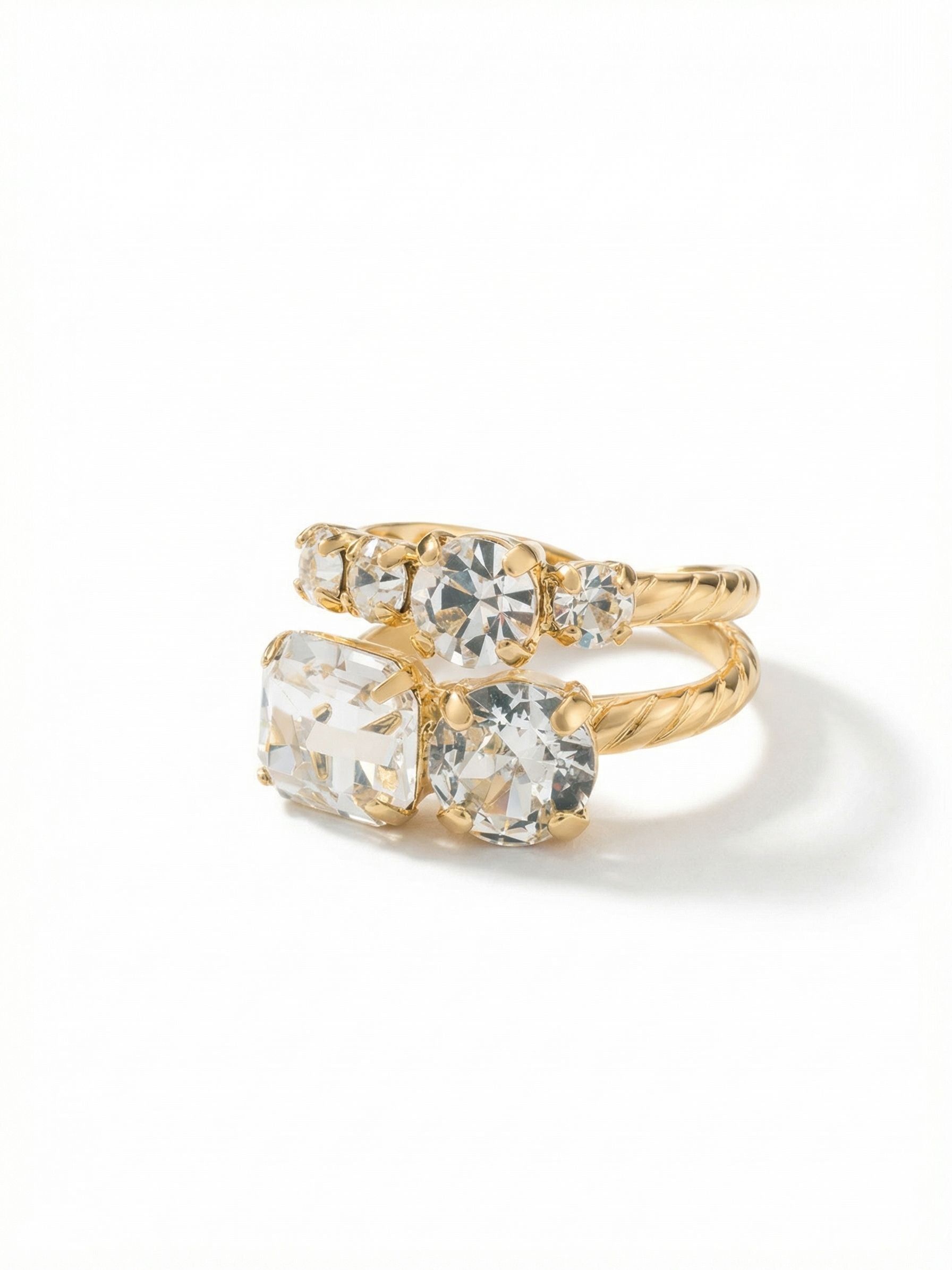 Miriam Stacked Ring - RFC44BGCRY - <p>The Miriam Stacked Ring creates the look of a carefully curated collection in one distinct piece. A prominent emerald-cut clear crystal grounds the arrangement, balanced by a descending rhythm of round cuts that shift and catch the light as you talk with your hands. The twisted rope texture of the band adds tactile interest, while the open design gently adjusts to your finger. It offers substantial presence without feeling heavy, easily transitioning from morning meetings to evening dinners.</p><ul>
<li>Asymmetric arrangement of emerald and round cuts creates varied light refraction</li>
<li>Twisted metal band adds a tactile element to the stacked silhouette</li>
<li>Adjustable ring band</li>
<li>Protective e-coat finish for lasting wear</li>
<li>Includes signature organza pouch for gifting and travel</li>
</ul>