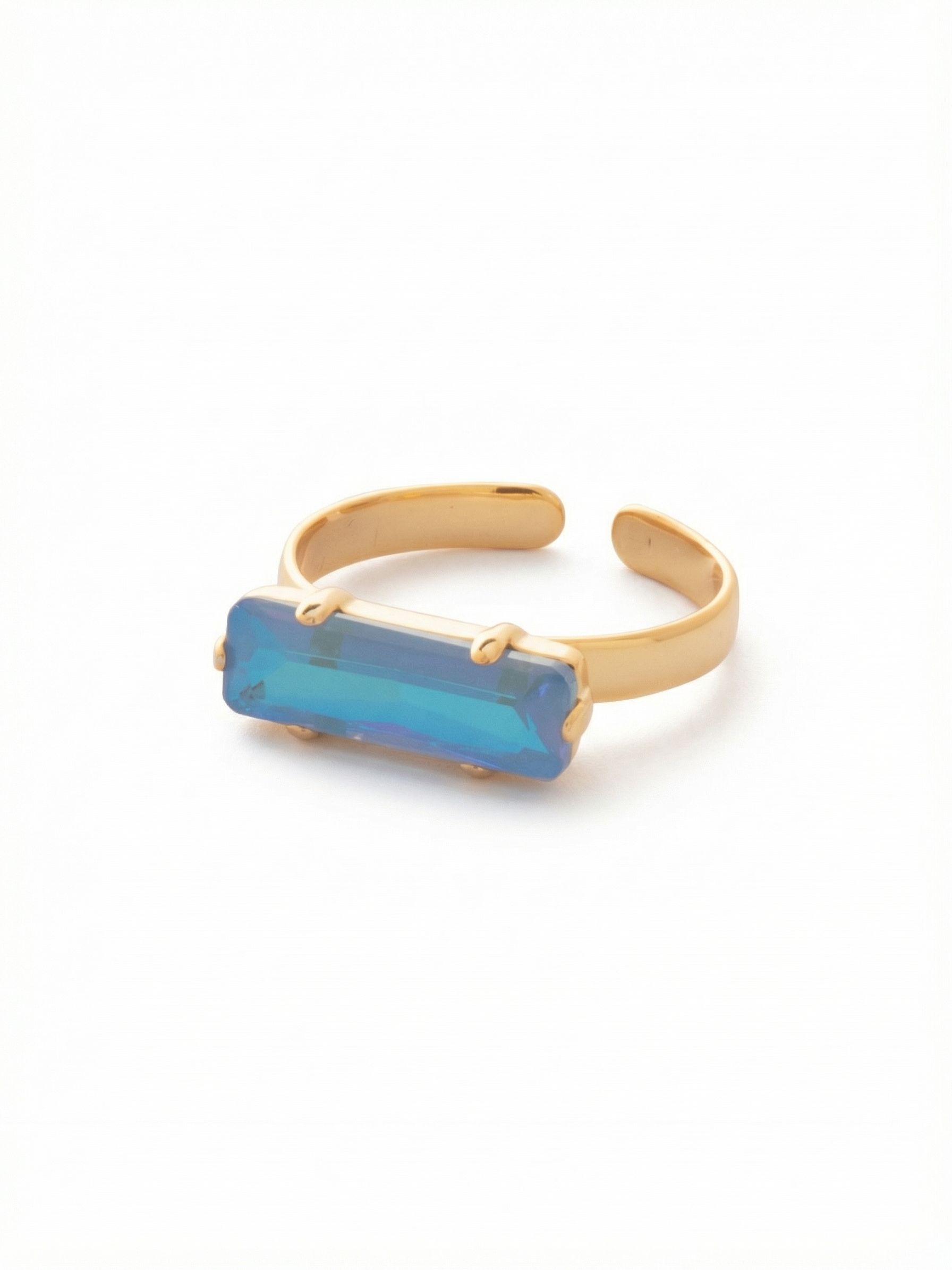 Bindi Band Ring - RFS2BGOCD - <p>A clean, linear presence on the hand. This ring centers a single elongated baguette crystal, set horizontally to span the width of your finger. Six understated prongs secure the stone, letting light travel through the shifting blue and teal facets with every gesture. The open back allows you to easily adjust the fit, giving you the freedom to move it between fingers. It is a quiet but confident wash of color that works seamlessly into your daily rotation.</p><ul>
<li>East-west baguette setting creates a clean horizontal line</li>
<li>Elongated rectangular cut maximizes the visible color shift</li>
<li>Adjustable ring band</li>
<li>Protective e-coat finish for lasting wear</li>
<li>Includes signature organza pouch for gifting and travel</li>
</ul>