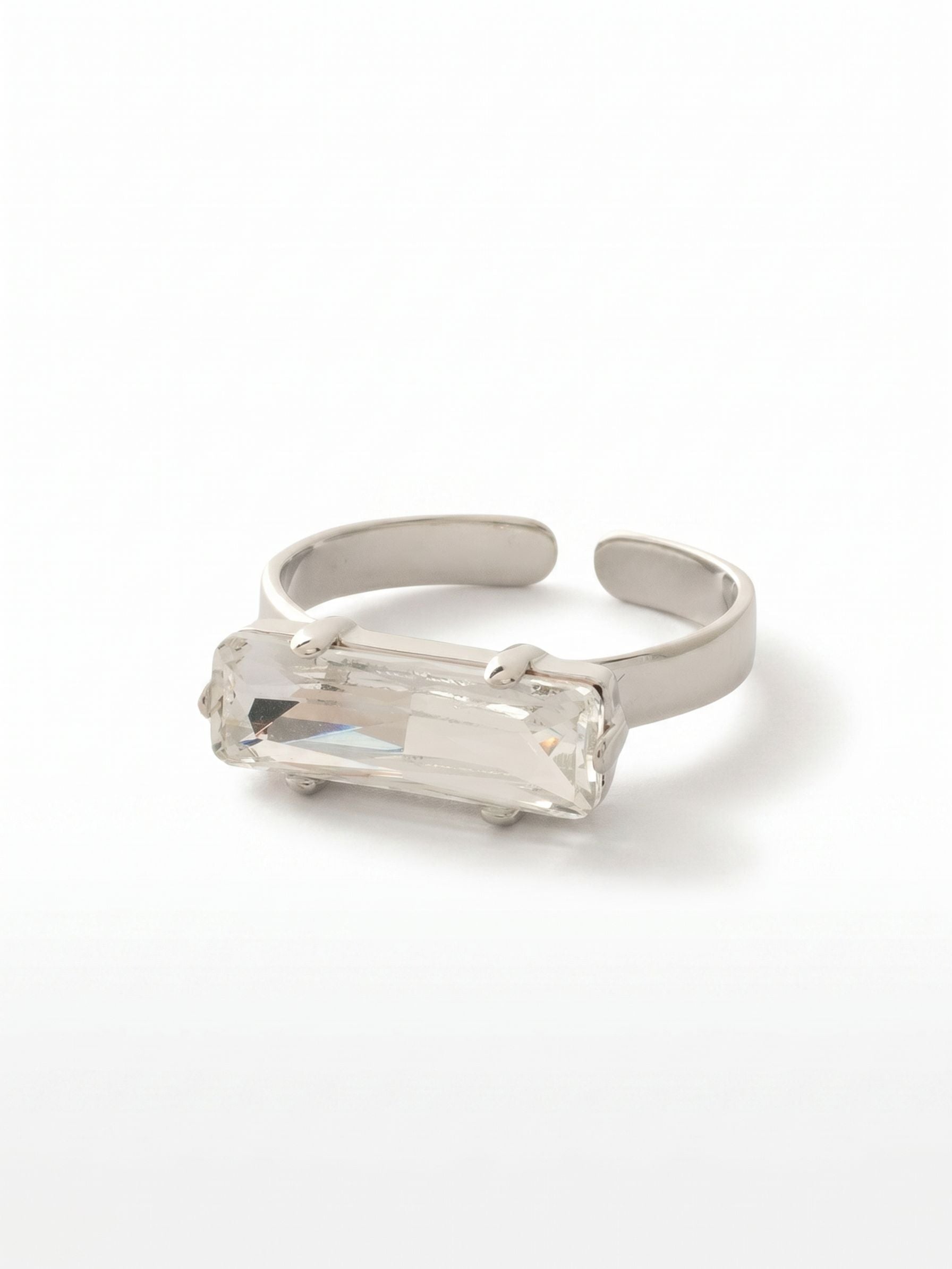 Bindi Band Ring - RFS2PDCRY - <p>An east-west setting changes the entire personality of a ring. By turning a single elongated baguette crystal on its side, the design stretches out across the finger for a sleek, linear look that feels distinctly modern. The clear crystal catches light with every gesture of the hand, bringing sharp, icy clarity to a minimalist profile. An open, adjustable band allows you to easily switch this piece between fingers or accommodate slight changes in fit throughout the day.</p><ul>
<li>Single elongated baguette crystal in a modern east-west setting</li>
<li>Clean architectural lines that stretch horizontally across the finger</li>
<li>Adjustable ring band</li>
<li>Protective e-coat finish for lasting wear</li>
<li>Includes signature organza pouch for gifting and travel</li>
</ul>