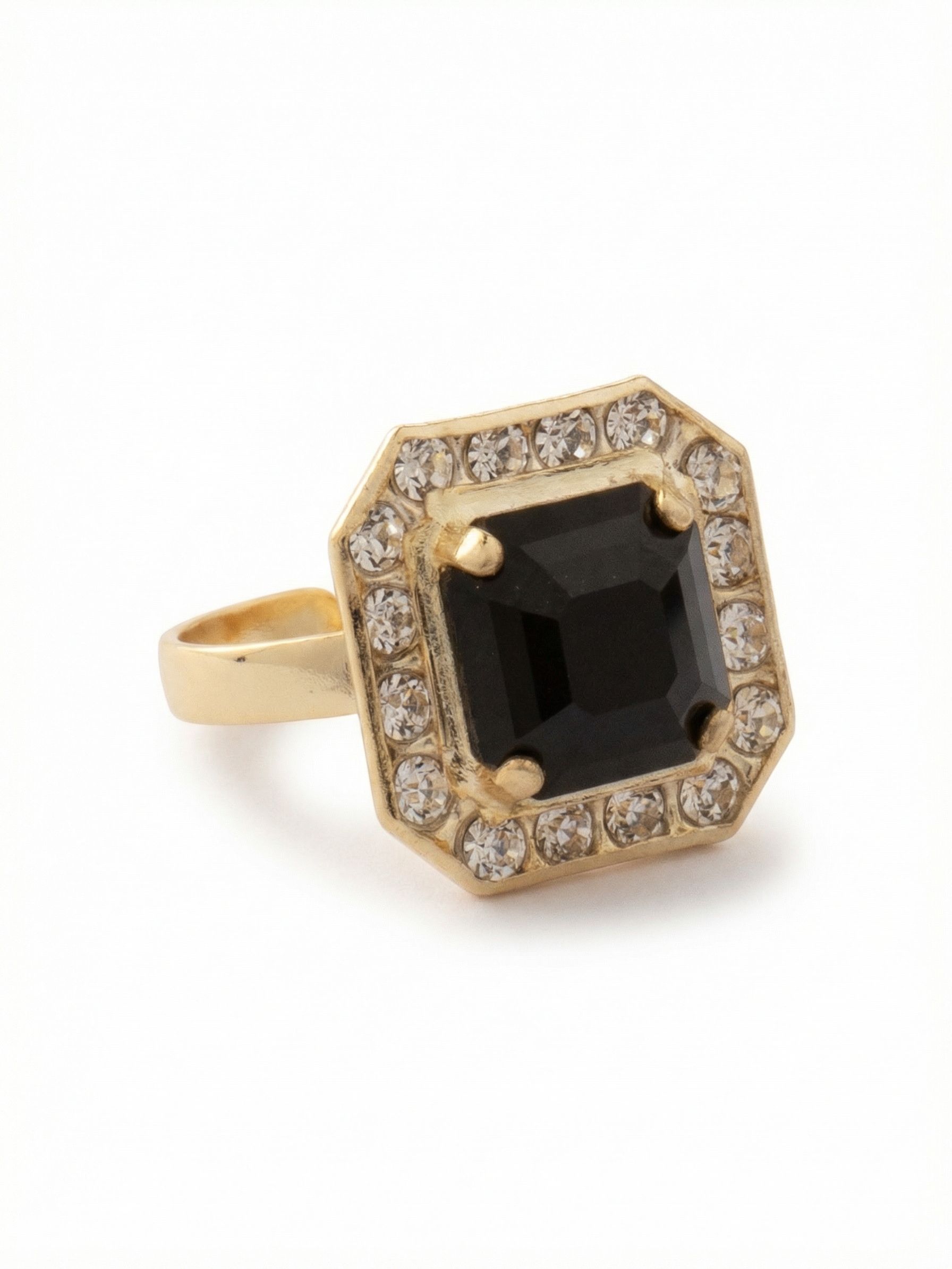 Autumn Cocktail Ring - RFS5BGEM - <p>A single, deep black Jet crystal anchors this geometric cocktail ring, creating a sharp contrast against the bright gold-tone setting. The ten-millimeter square-cut center stone is framed by a structured border of light-catching accents, giving the piece a distinct, vintage-inspired profile on the hand. Designed with a flexible open band, it adjusts easily to fit different fingers, letting you shift its placement depending on your mood or the other rings you choose to wear.</p><ul>
<li>Deep black square-cut center stone in a geometric setting</li>
<li>Octagonal framing adds an architectural element to the hand</li>
<li>Adjustable ring band</li>
<li>Protective e-coat finish for lasting wear</li>
<li>Includes signature organza pouch for gifting and travel</li>
</ul>