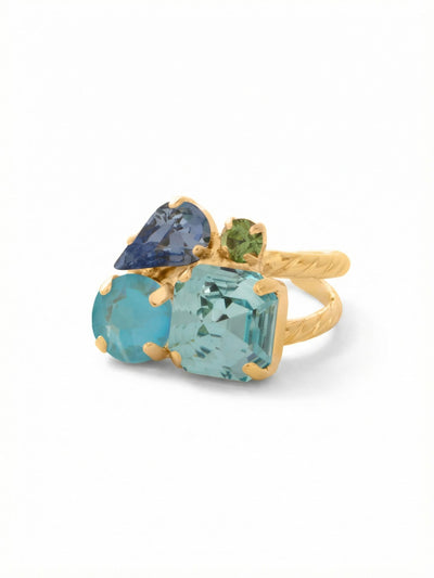 Anika Adjustable Cocktail Ring - RFY11BGOC - <p>Four distinct crystal shapes gather in an asymmetrical cluster, catching the light as you talk with your hands or reach for a coffee cup. A structured aquamarine square anchors the arrangement, softened by shifting tones of blue and a tiny pop of peridot green. This interplay of color and cut creates a fluid visual rhythm. The open, rope-textured band gives you the flexibility to easily adjust the fit or move the piece between fingers throughout the week.</p><ul>
<li>Asymmetrical cluster of contrasting mixed crystal shapes</li>
<li>Cool aquatic palette anchored by a structured square profile</li>
<li>Adjustable ring band</li>
<li>Protective e-coat finish for lasting wear</li>
<li>Includes signature organza pouch for gifting and travel</li>
</ul>