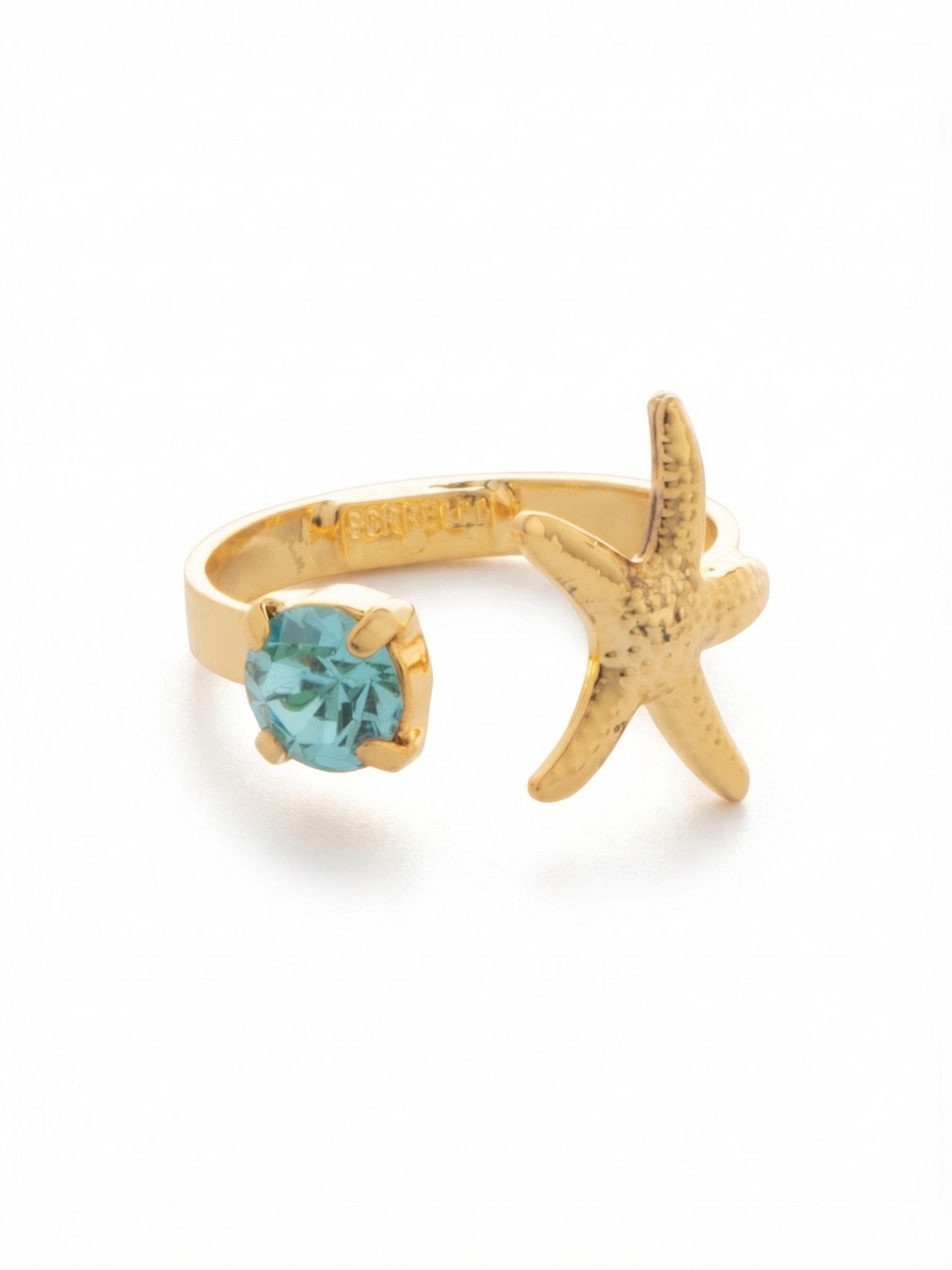 Starfish Open Band Ring - RGE3BGCSD - <p>A gentle asymmetry defines this open band ring. On one side, a textured golden starfish rests closely against your finger. It meets a single round-cut aqua crystal that captures the ambient light with every subtle movement of your hand. The open silhouette creates an airy negative space, allowing both elements to float effortlessly. An adjustable band provides a personalized, comfortable fit that adapts easily to you, bringing a bright focal point to your everyday rotation.</p><ul>
<li>Asymmetrical open design balancing a metallic charm with crystal shine</li>
<li>Airy negative space creates the illusion of floating elements</li>
<li>Adjustable ring band</li>
<li>Protective e-coat finish for lasting wear</li>
<li>Includes signature organza pouch for gifting and travel</li>
</ul>