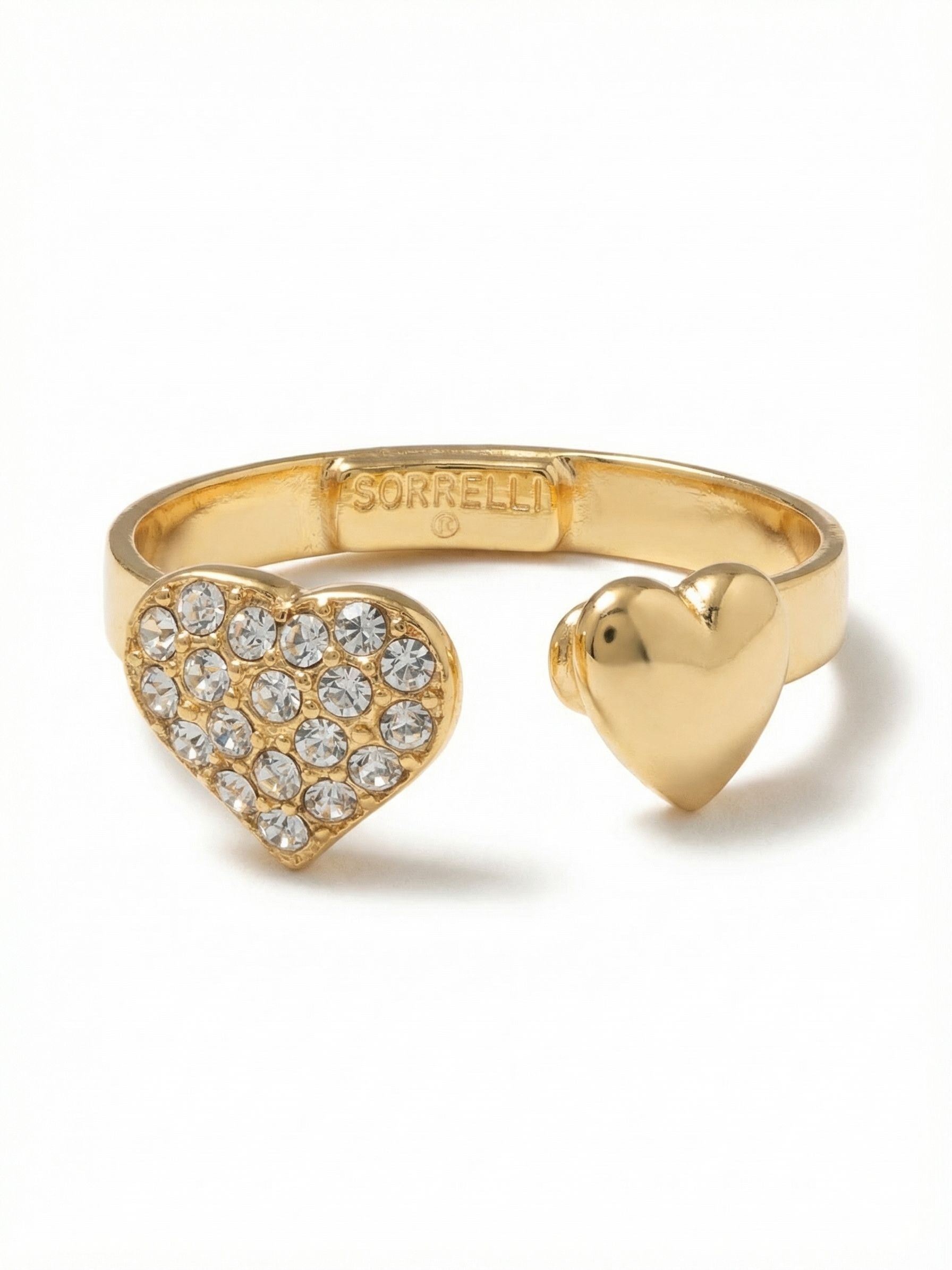 Open Heart Adjustable Band Ring - RGF1BGCRY - <p>Two asymmetrical hearts meet across an open metal band. One side catches the light with a dense layer of clear round-cut crystals, balancing the smooth polished finish of the opposite heart. The open silhouette feels airy on the hand and offers gentle flexibility, allowing you to easily shift the ring between fingers for a comfortable, custom fit. It brings a subtle, considered detail to your everyday rotation.</p><ul>
<li>Asymmetrical dual heart motifs contrasting crystal pave against smooth metal</li>
<li>Low-profile silhouette sits close to the hand for easy daily movement</li>
<li>Adjustable ring band</li>
<li>Protective e-coat finish for lasting wear</li>
<li>Includes signature organza pouch for gifting and travel</li>
</ul>