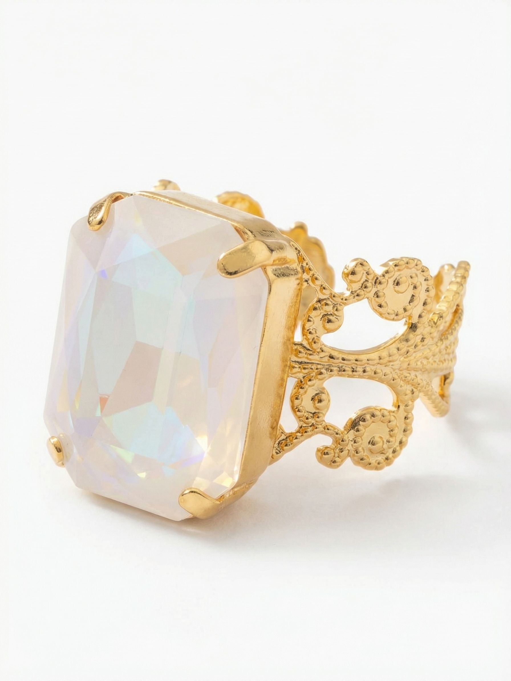 Brynn Cocktail Ring - RGK2BGUWAB - <p>A substantial emerald-cut crystal rests at the center of this ring, catching ambient light to reveal subtle, iridescent shifts of color as you move your hand. The intricately detailed filigree band provides an airy, structured foundation that balances the visual weight of the prominent stone. Built with an open back, the band adjusts easily for a comfortable, customized fit that adapts throughout the day.</p><ul>
<li>Prominent emerald-cut crystal with subtle color shifts</li>
<li>Intricate open-work filigree band with textured detailing</li>
<li>Adjustable ring band</li>
<li>Protective e-coat finish for lasting wear</li>
<li>Includes signature organza pouch for gifting and travel</li>
</ul>