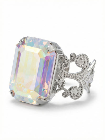 Brynn Cocktail Ring - RGK2PDCAB - <p>A single, substantial emerald-cut crystal anchors this piece, capturing a shifting spectrum of pastel light as your hands move throughout the day. The iridescent quality of the stone contrasts with the structured geometry of the cut, creating a constant play of color and shadow. Set on an intricate filigree band with detailed metalwork, the ring balances clean lines with vintage-inspired craftsmanship. The open design easily adjusts to fit different fingers, adapting quietly to your routine.</p><ul>
<li>Substantial emerald-cut center stone offering broad facets of shifting pastel light</li>
<li>Ornate open-metalwork band with intricate textured detailing</li>
<li>Adjustable ring band</li>
<li>Protective e-coat finish for lasting wear</li>
<li>Includes signature organza pouch for gifting and travel</li>
</ul>
