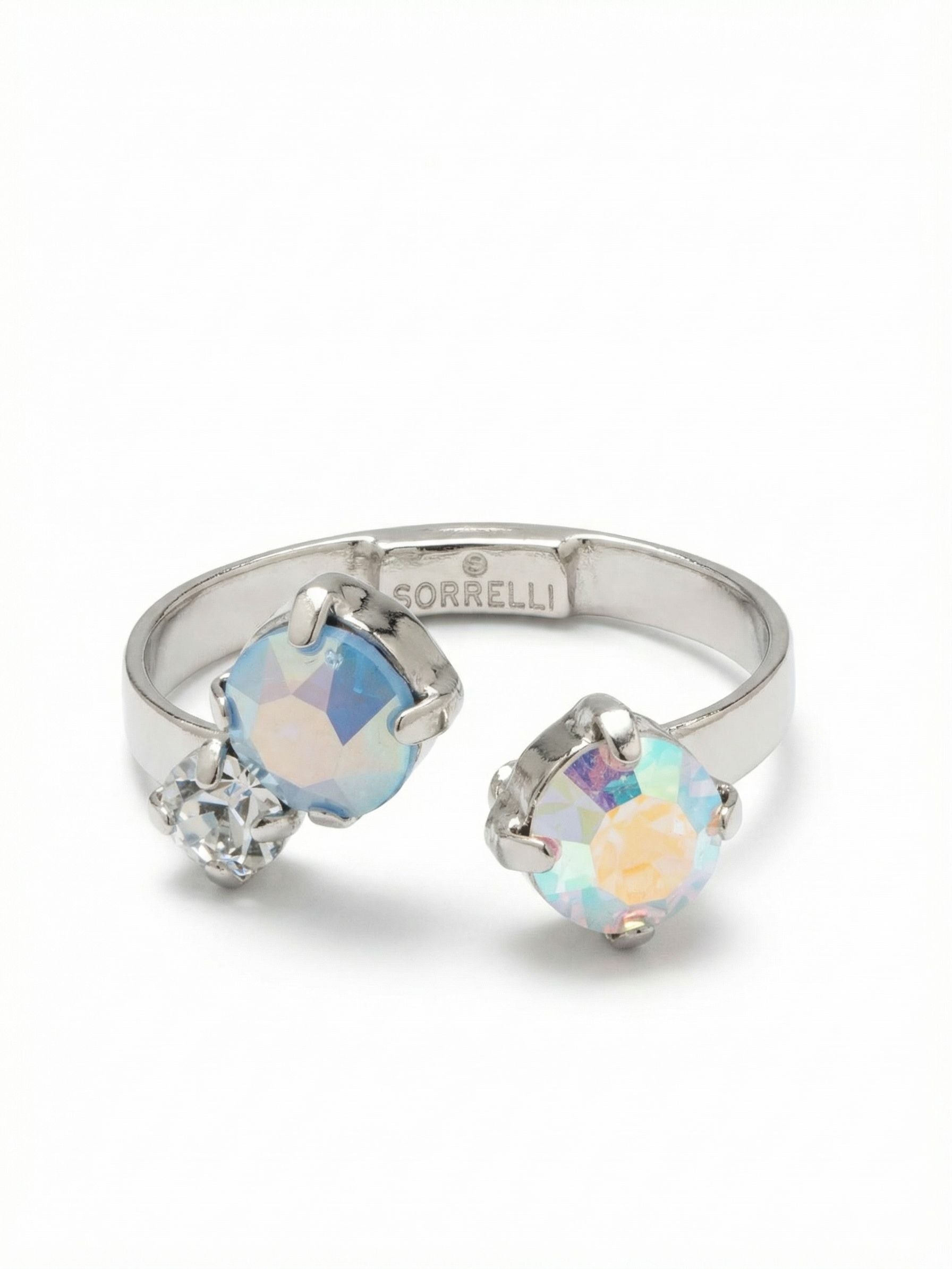 Bubbles Open Band Ring - RGK3PDRQ - <p>Three round crystals create an asymmetrical balance across an open metal band. A bright iridescent stone sits opposite a soft blue opal and a tiny clear accent, catching flashes of pastel color as your hands move. The open design leaves a touch of negative space on the finger while allowing you to gently adjust the fit. It is a versatile ring that adapts easily, letting you choose exactly where it belongs in your daily rotation.</p><ul>
<li>Asymmetrical cluster of iridescent and opal round-cut crystals</li>
<li>Open band leaves deliberate negative space on the finger</li>
<li>Adjustable ring band</li>
<li>Protective e-coat finish for lasting wear</li>
<li>Includes signature organza pouch for gifting and travel</li>
</ul>