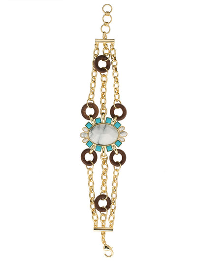 Dylan Statement Bracelet - BFD6BGSTO - <p>The Dylan Statement Bracelet features layered chains with wooden circle accents, with an oversized oval semi-precious stone nestled in a halo of assorted semi-precious stones, creating the perfect warm weather statement piece. From Sorrelli's Santorini collection in our Bright Gold-tone finish.</p>