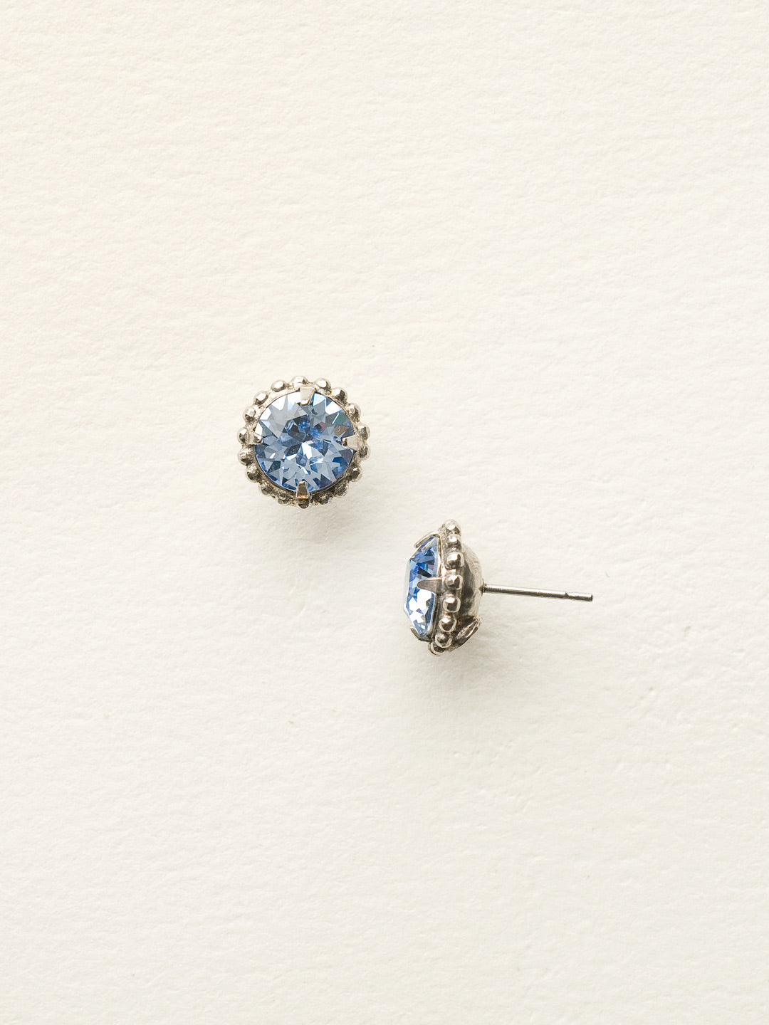 Simplicity Stud Earrings - EBY38ASLTS - <p>A timeless classic, the Simplicity Stud Earrings feature round cut crystals in a variety of colors; accented with a halo of metal beaded detail. Need help picking a stud? <a href="https://www.sorrelli.com/blogs/sisterhood/round-stud-earrings-101-a-rundown-of-sizes-styles-and-sparkle">Check out our size guide!</a> From Sorrelli's Light Sapphire collection in our Antique Silver-tone finish.</p>