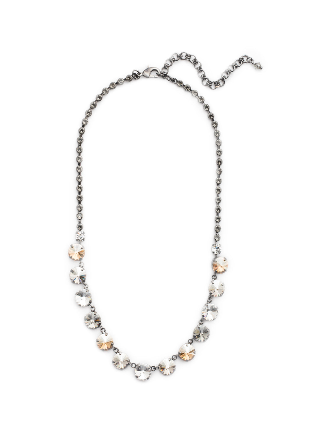 Ashley Rivoli Tennis Necklace - NCU19GMGNS - A classic beauty! This necklace boasts a little extra flare with its beautifully faceted rivoli crystals and decorative stone encrusted chain. You're set to sparkle from every angle. From Sorrelli's Golden Shadow collection in our Gun Metal finish.
