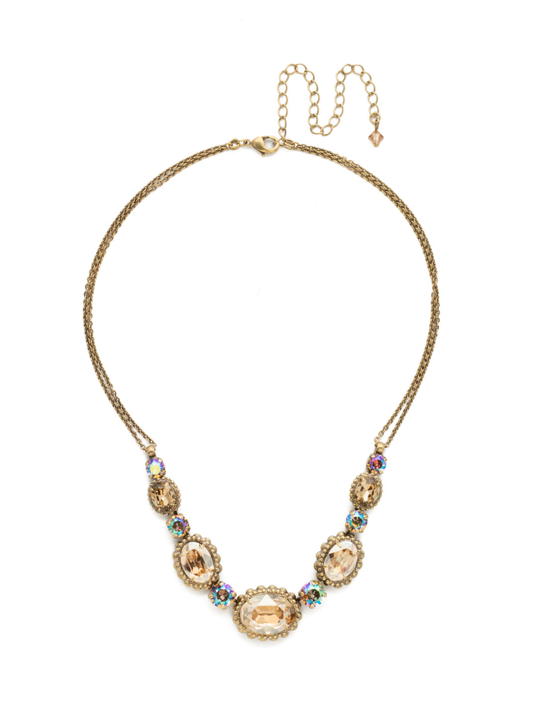 Camellia Necklace - NDQ10AGNT - <p>A delicate double chain adds subtle detail to this charming style. Five oval crystals with decorative metal edging are highlighted by petite round stones for a dynamic, dazzling look. From Sorrelli's Neutral Territory collection in our Antique Gold-tone finish.</p>