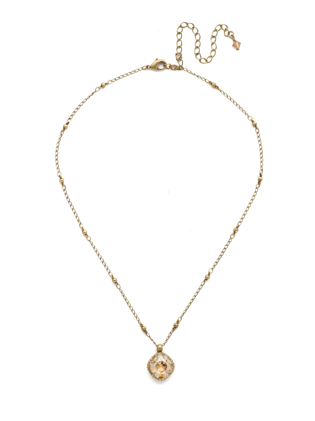 Cushion-Cut Pendant Necklace - NDS50AGDCH - <p>Elevate your jewelry collection with this artisanally handcrafted pendant necklace. The solitaire 12mm cushion cut crystal is surrounded by a beautifully scalloped edge, creating a unique and eye-catching design. The little ball details along the chain add a touch of character. This adjustable necklace features a 16 inch chain with a 4 inch extension, complete with a delicate charm, for a versatile fit. Whether you're looking for a special gift or a treat for yourself, this handcrafted necklace is a stylish and timeless choice. From Sorrelli's Dark Champagne collection in our Antique Gold-tone finish.</p>