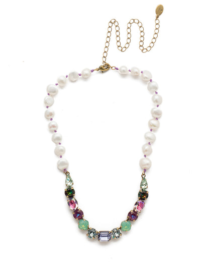 Cadenza Tennis Necklace - NEC14AGIRB - This classic beauty features a chain of wire-wrapped freshwater pearls supporting a delicate pattern of crystal shapes at its base. From Sorrelli's Iris Bloom collection in our Antique Gold-tone finish.