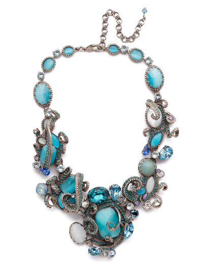 Aquatic Azure Statement Necklace - NSP3ASAQU - With elegant white and clear crystals, the Aquatic Bib Necklace in White Bridal is a bold and perfect accessory to your dress on your day. The aurora borealis effect creates shades of blue and amethyst when light reflects on the crystal, keeping the necklace rooted in its aquatic inspiration, but subtlety adding just enough color and detail to keep the spotlight on you. Whether you are beach side, or simply love the sea at heart, this necklace will help you sparkle on your big day. From Sorrelli's Aquamarine collection in our Antique Silver-tone finish.
